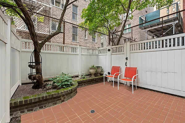 a view of a chairs and table in the back yard of the house