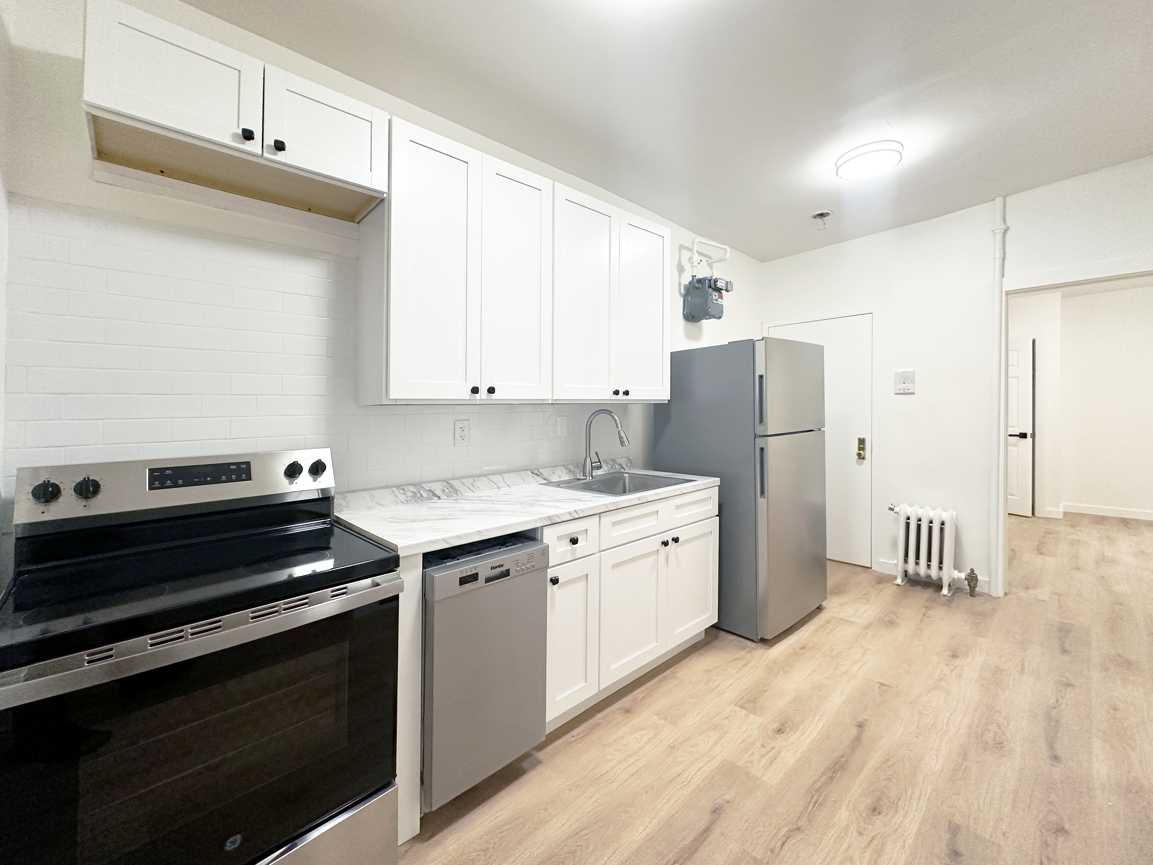 a kitchen with a refrigerator stove and white cabinets