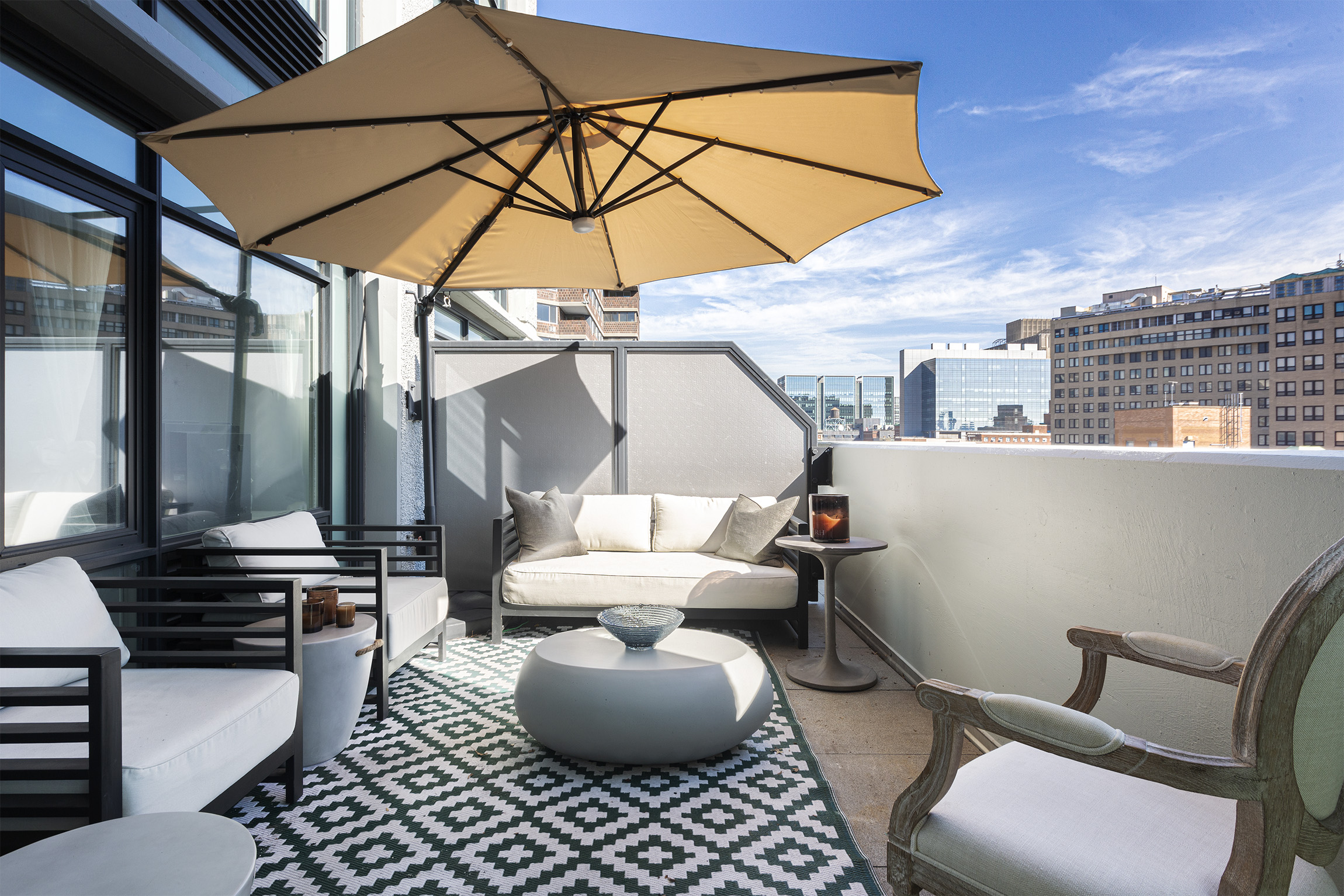 a view of a patio with couches table and chairs under an umbrella