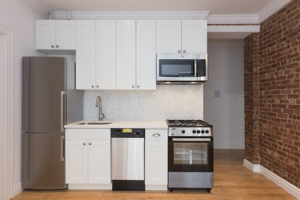 a kitchen with stainless steel appliances white cabinets and a stove a refrigerator with wooden floor