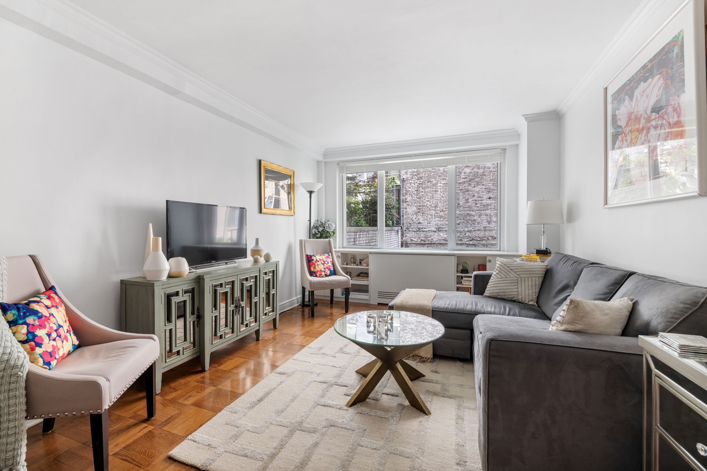 a living room with furniture a flat screen tv and a window