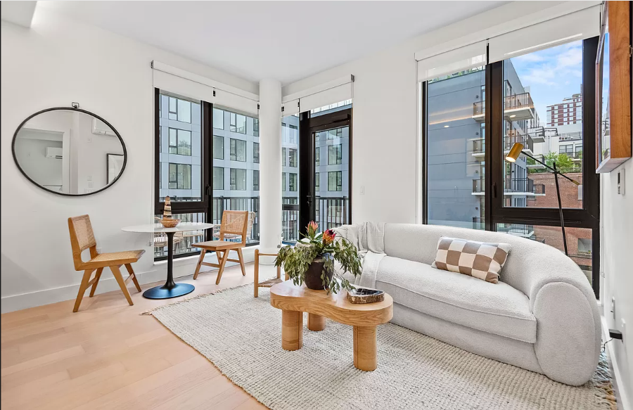 a living room with furniture a table and a large window