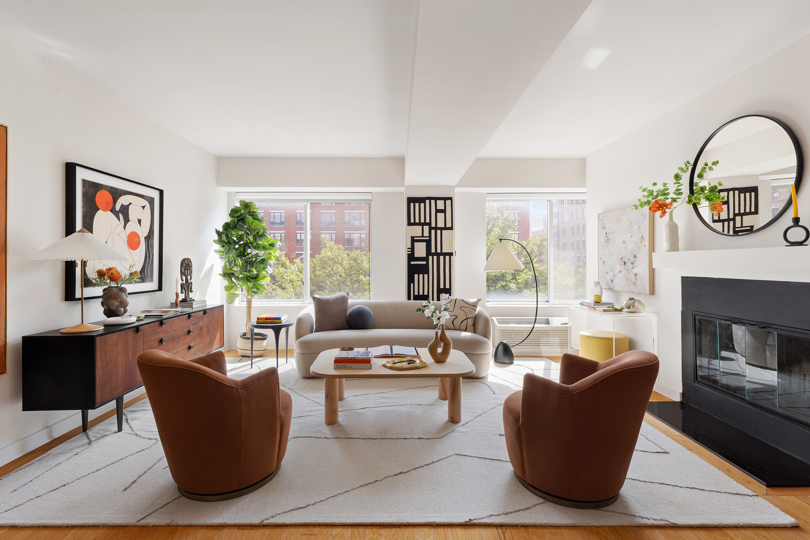 a living room with fireplace furniture and a large window