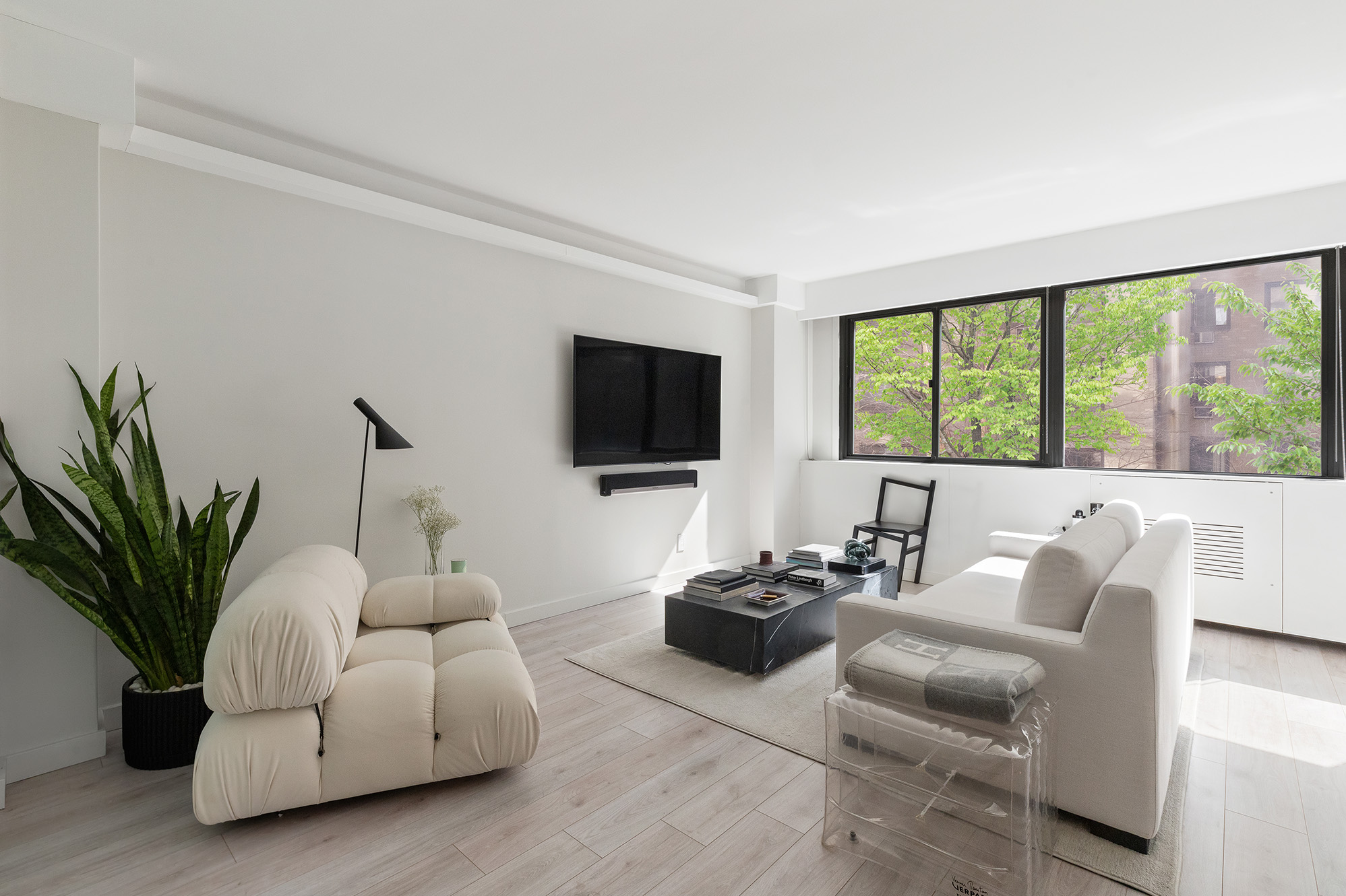 a living room with furniture tv and a large window