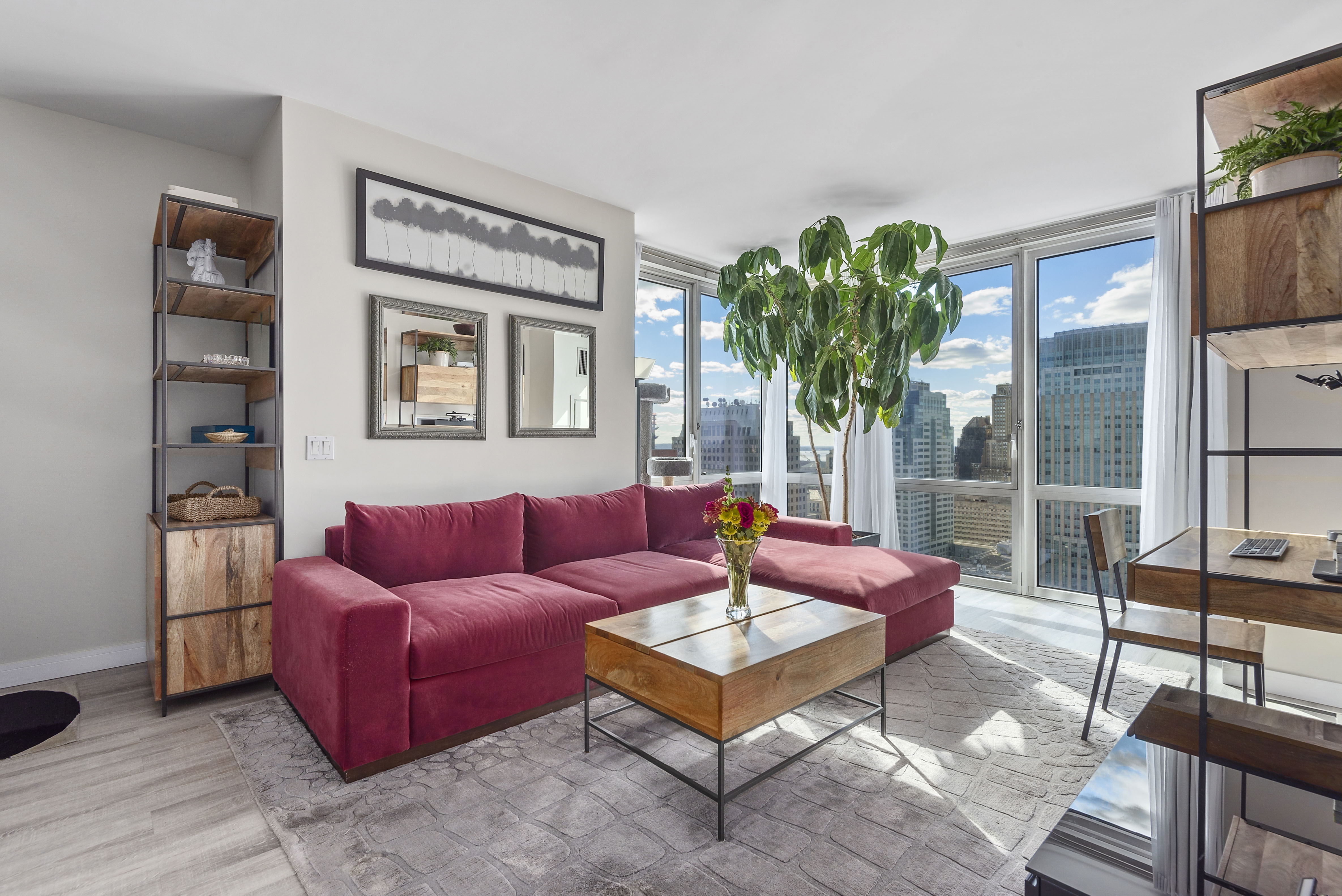 a living room with furniture potted plant and a large window