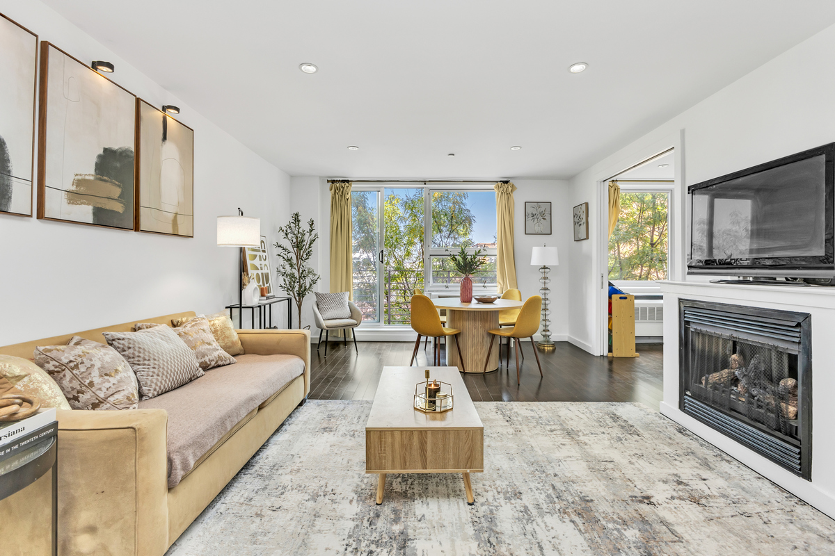 a living room with furniture a large window and a fireplace