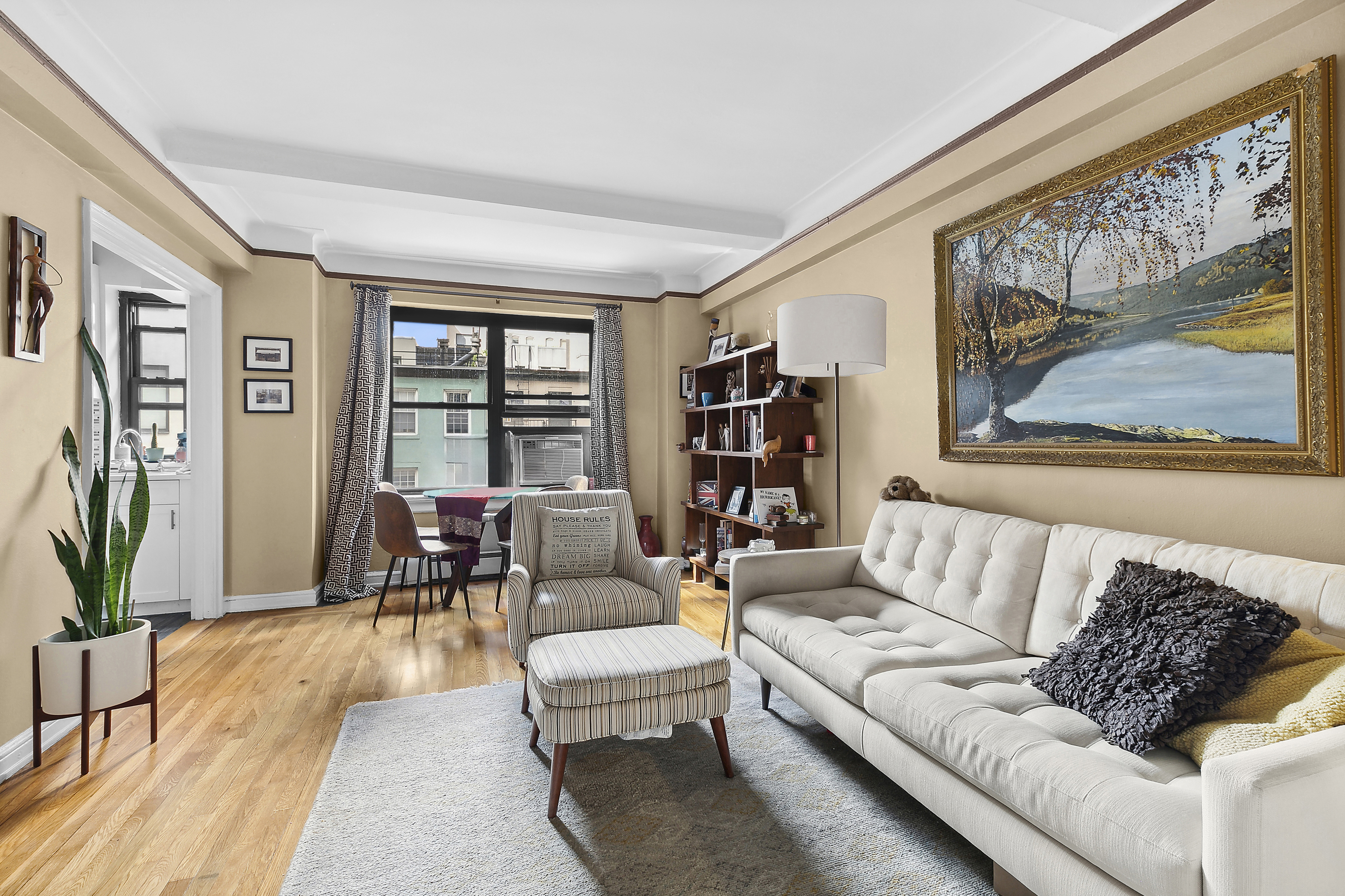 a living room with furniture and a large window with wooden floor