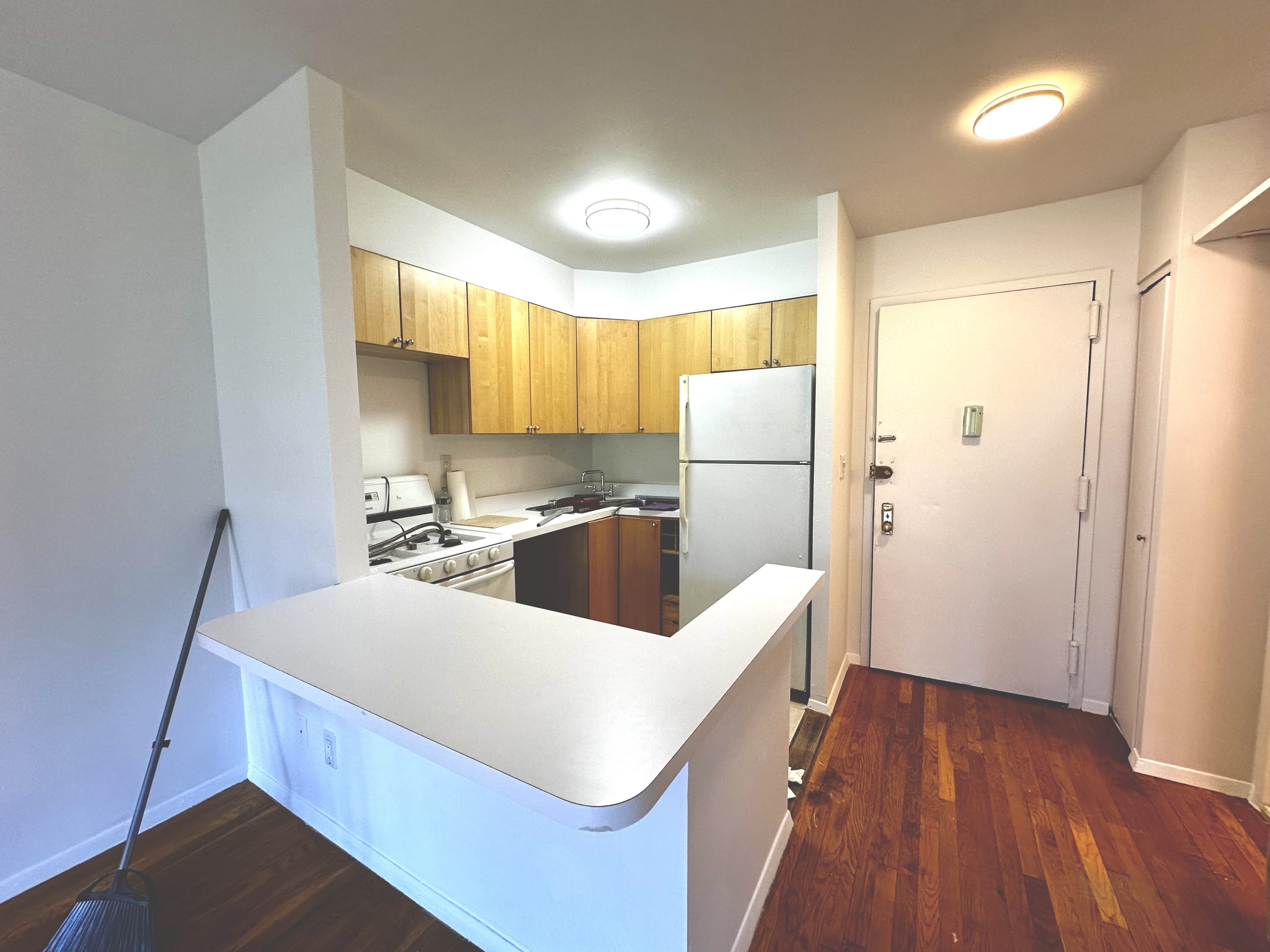 a kitchen with a refrigerator a sink and wooden floor