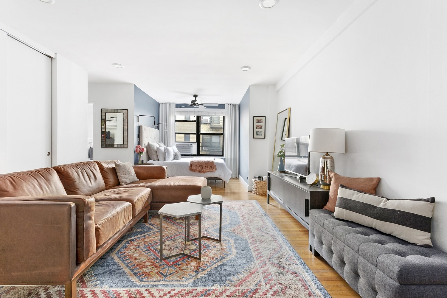 a living room with furniture wooden floor and a lamp