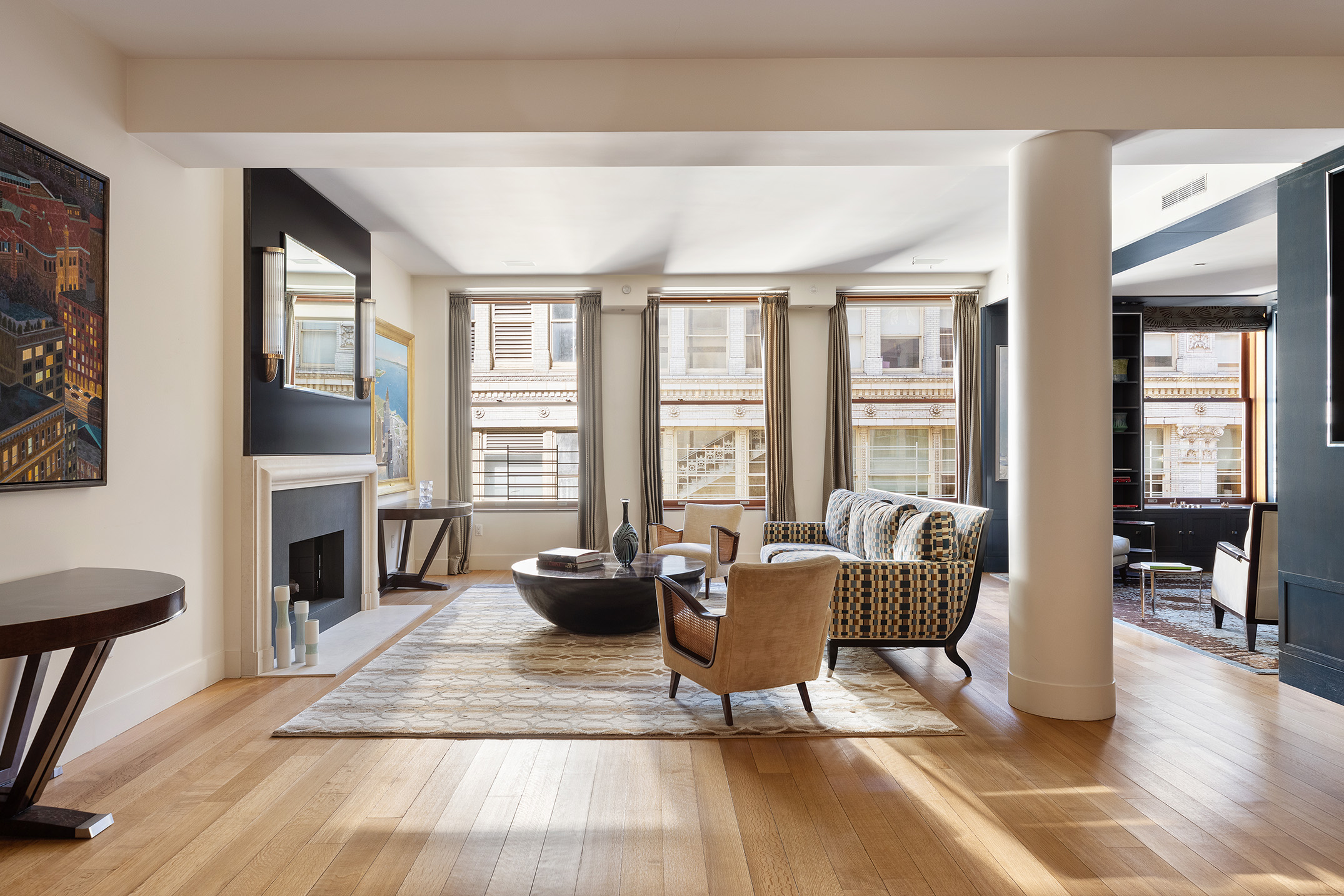 a living room with furniture a fireplace and large windows