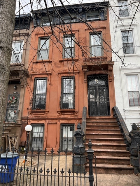 a view of a brick house with large windows