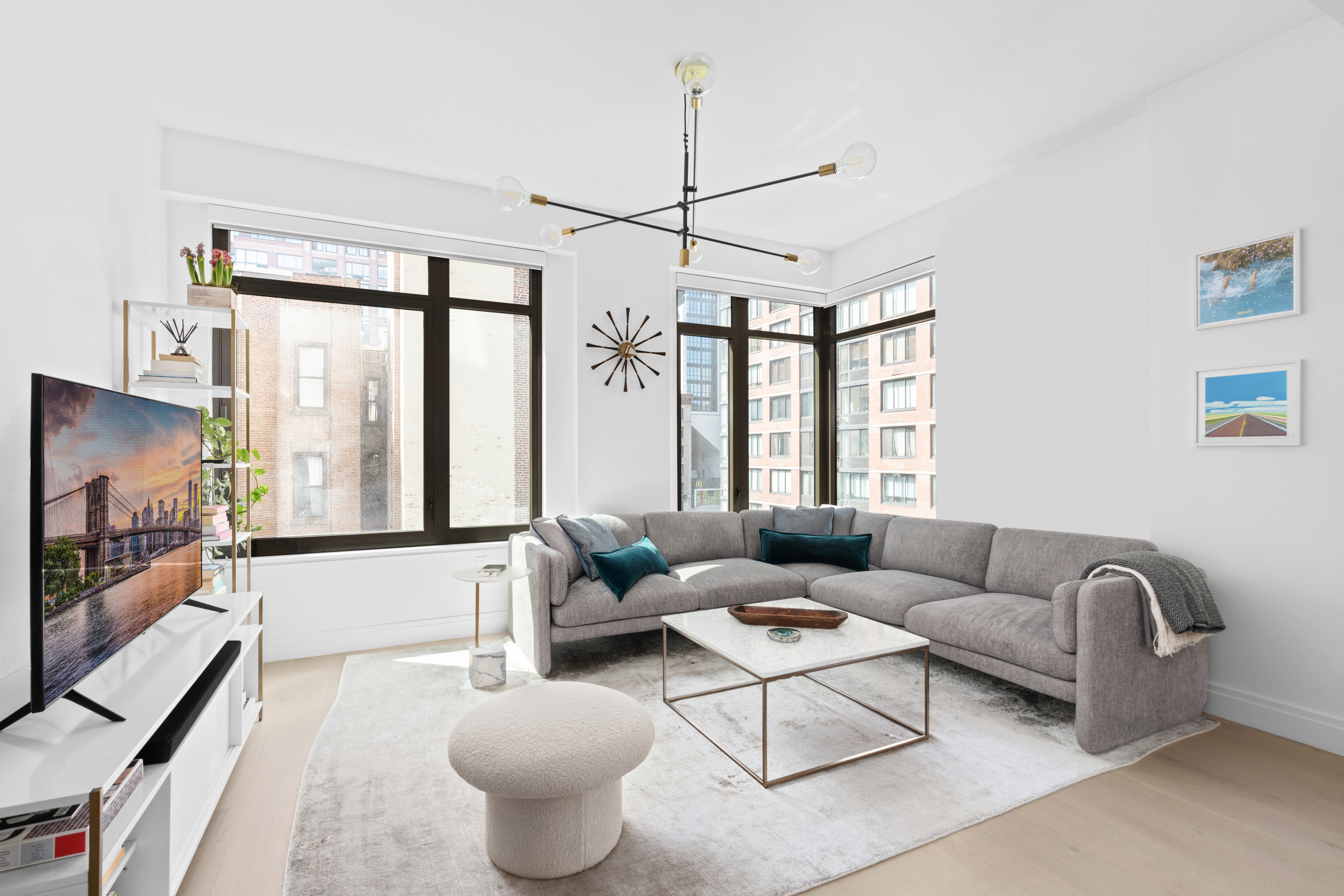 a living room with furniture a flat screen tv and a large window