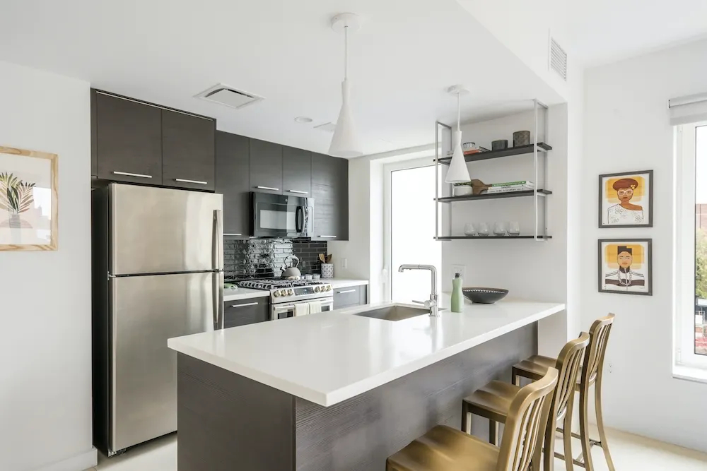 a kitchen with a refrigerator a dining table and chairs