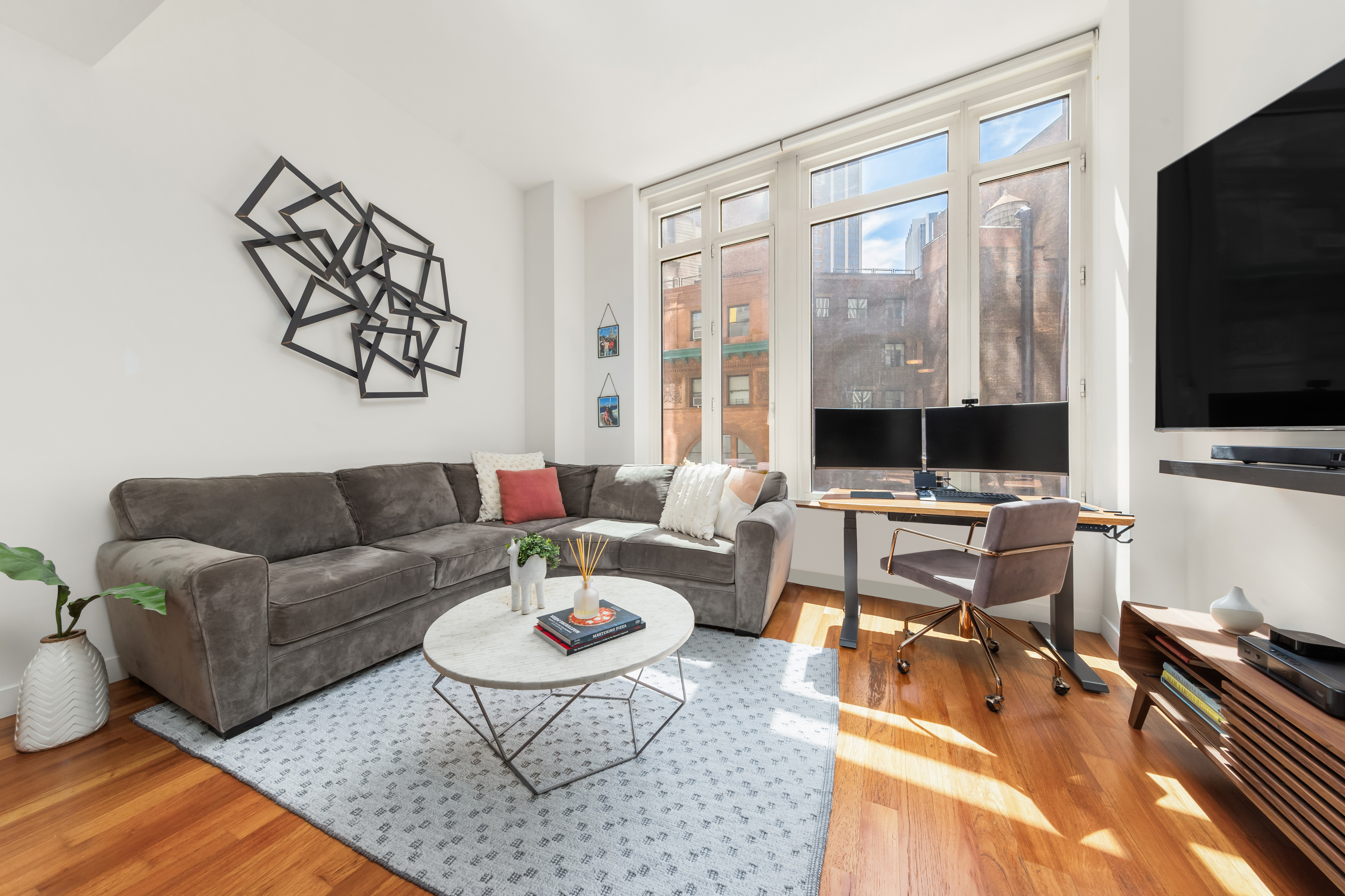 a living room with furniture a flat screen tv and a large window