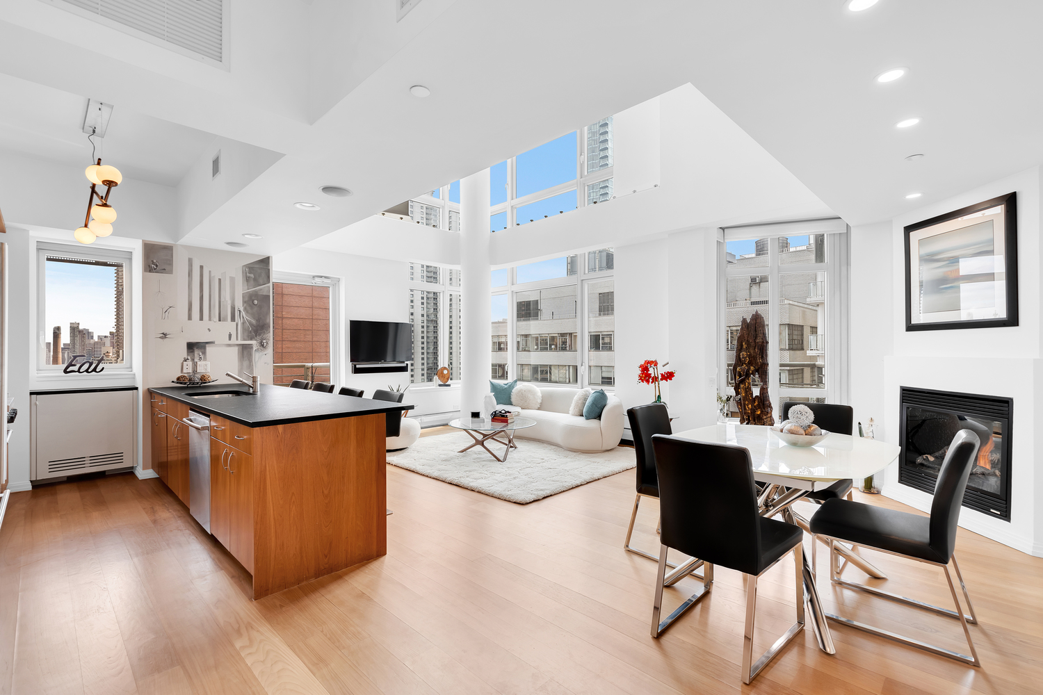 a living room with granite countertop furniture a fireplace and a kitchen view