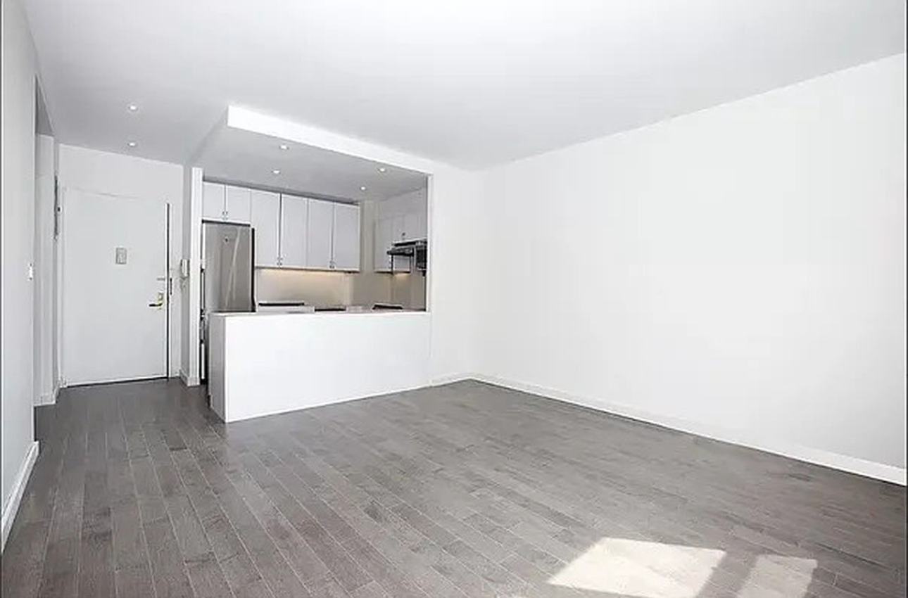 a view of a kitchen with wooden floor and electronic appliances