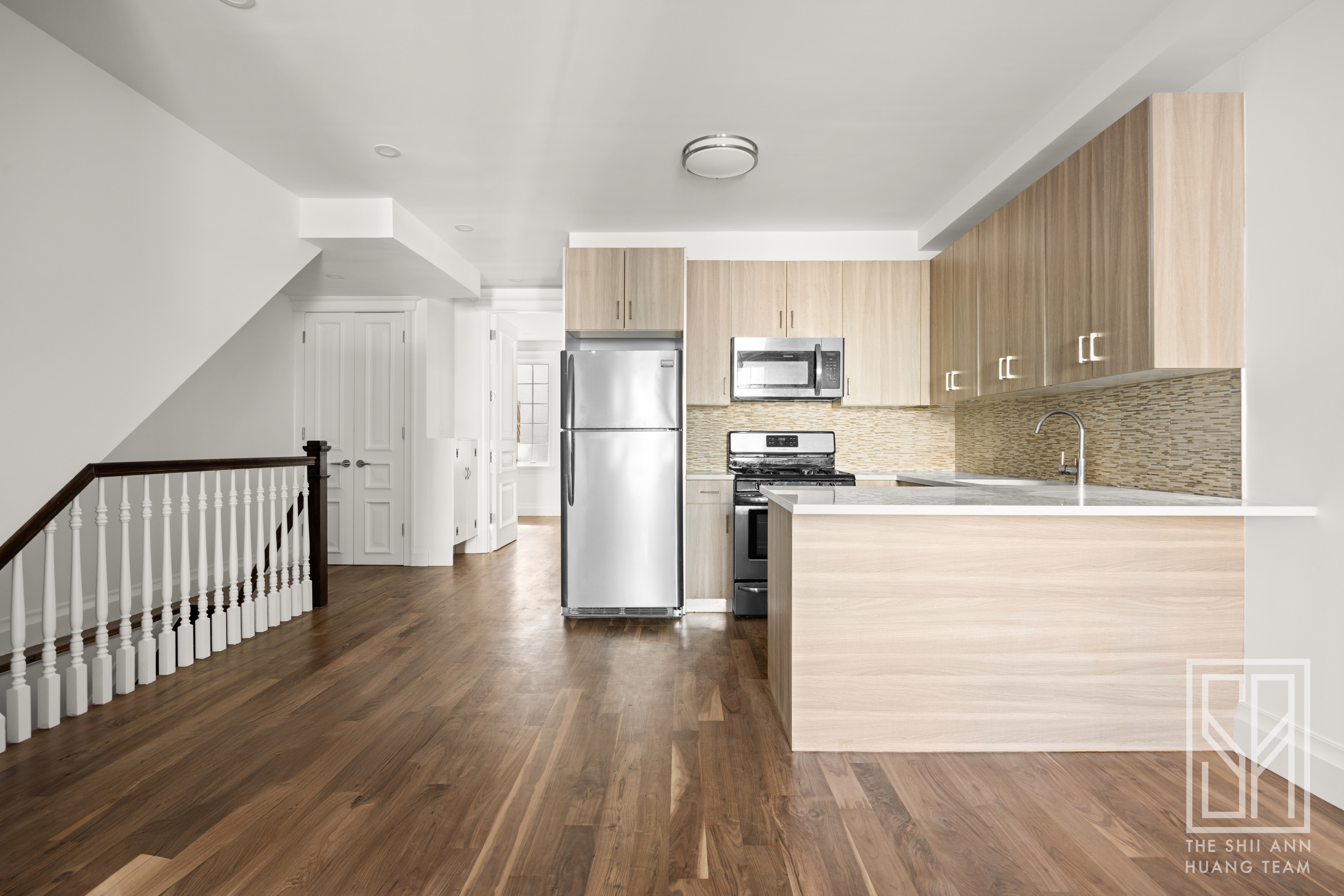 a kitchen with stainless steel appliances wooden floors and wooden cabinets