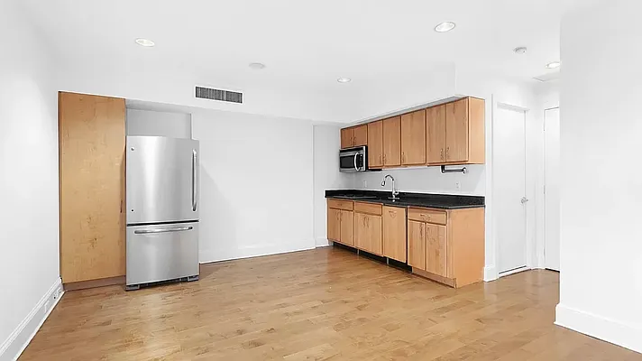 a kitchen with stainless steel appliances granite countertop a refrigerator and a stove top oven