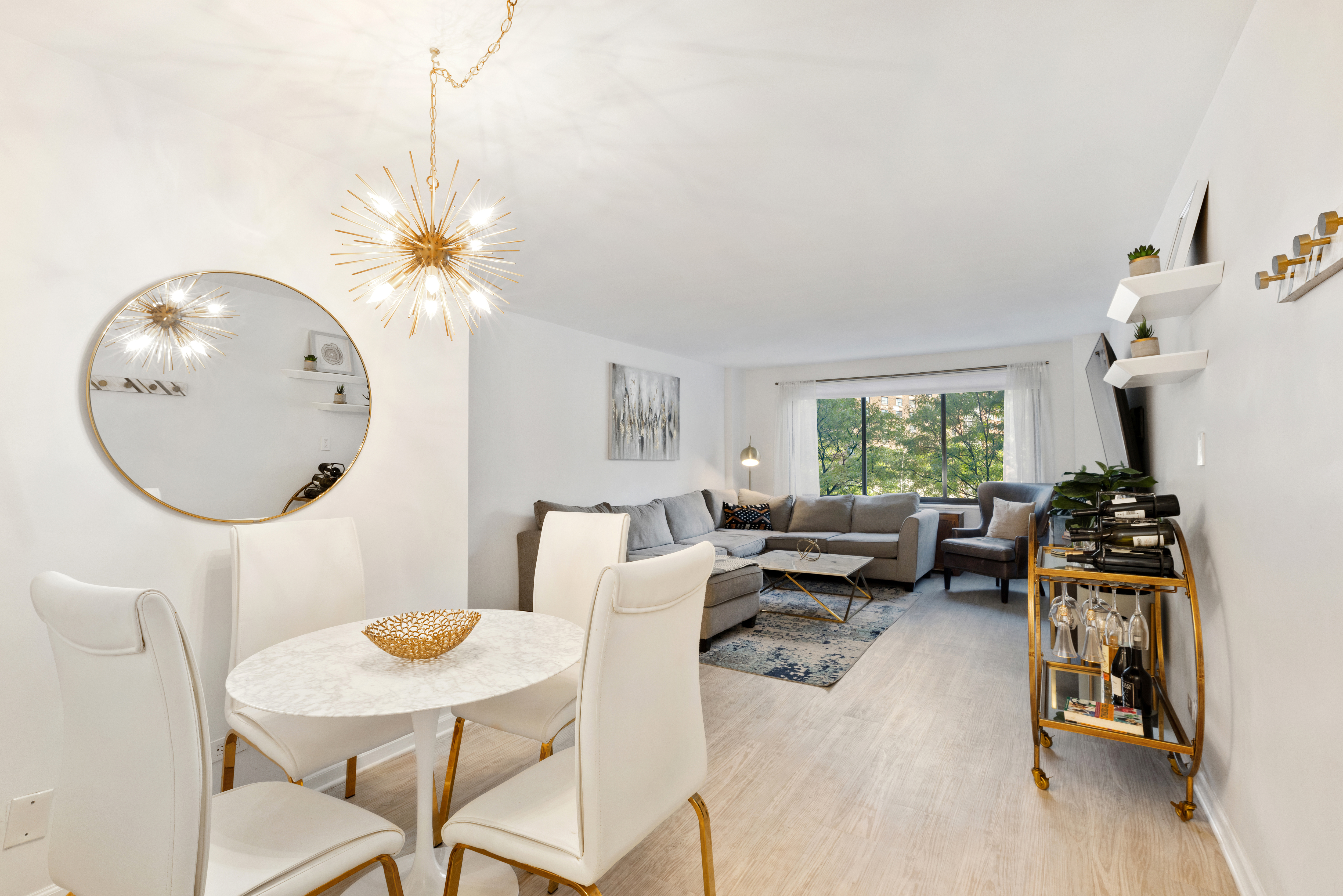 a living room with furniture a chandelier and a table