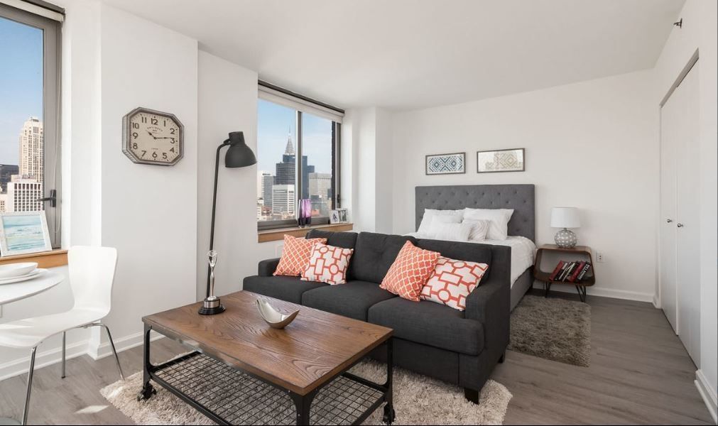 a living room with furniture a clock on wall and a window