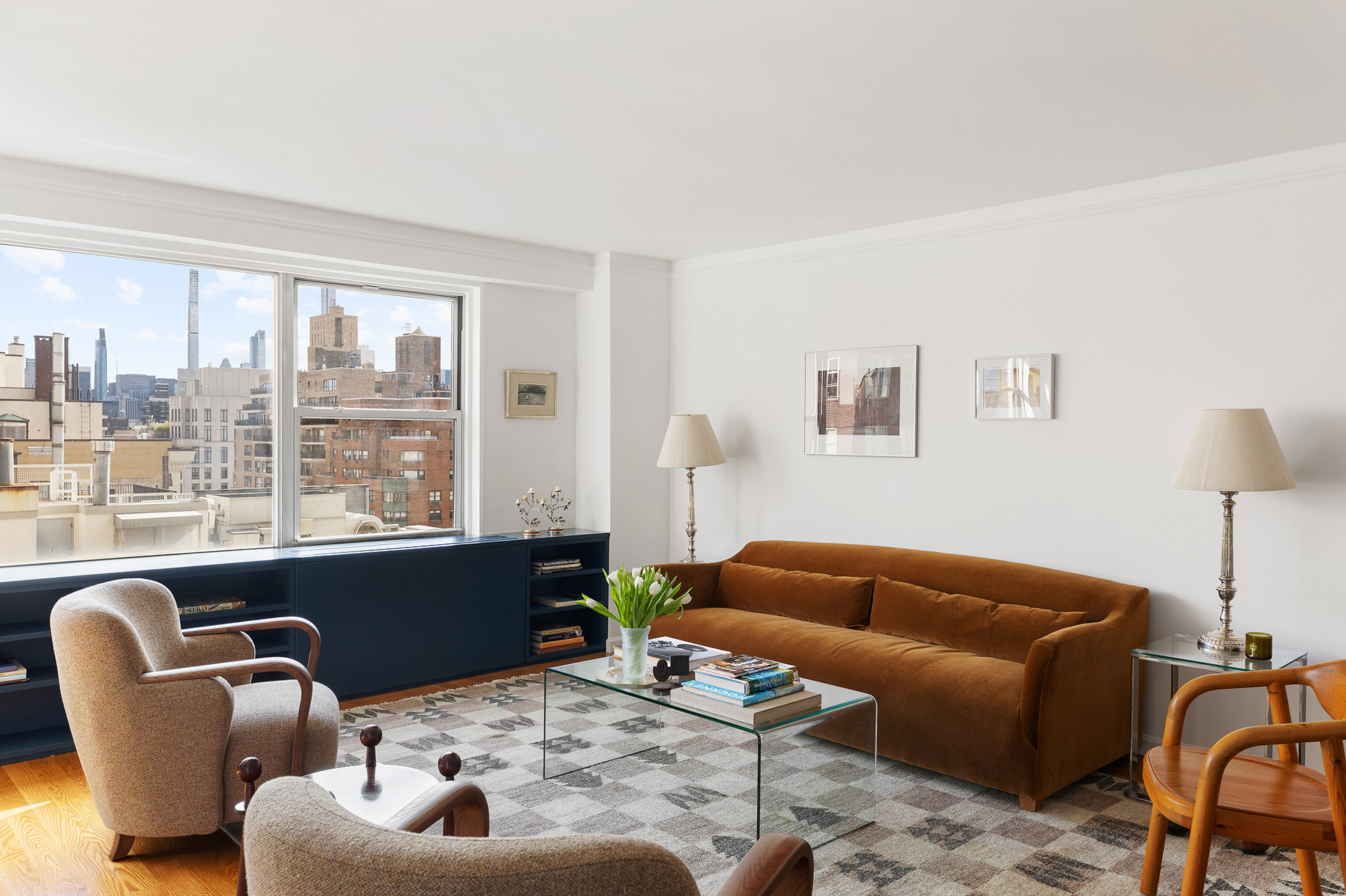 a living room with furniture a lamp wooden floor and a large window