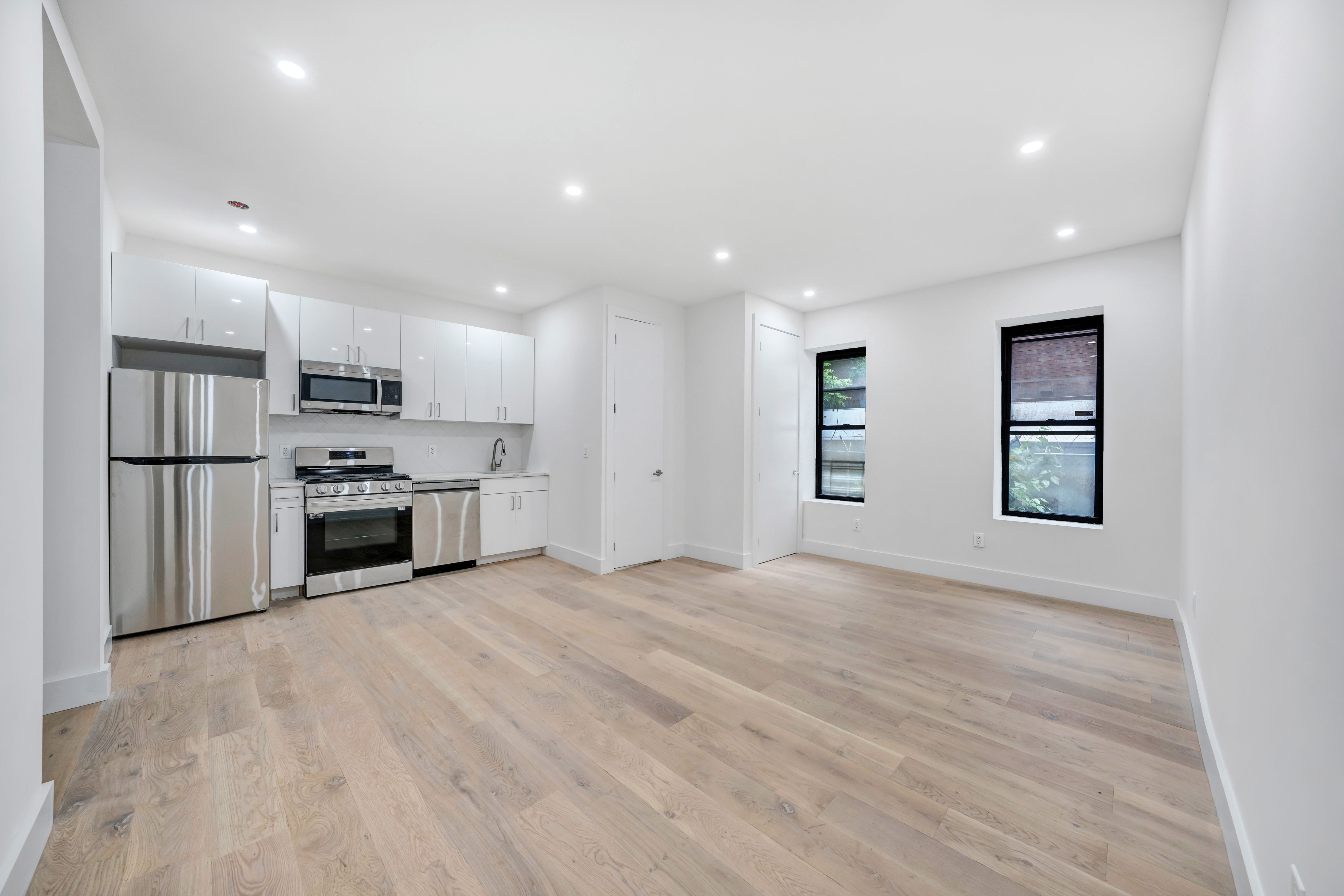 a view of kitchen with stainless steel appliances granite countertop a stove a sink and a refrigerator