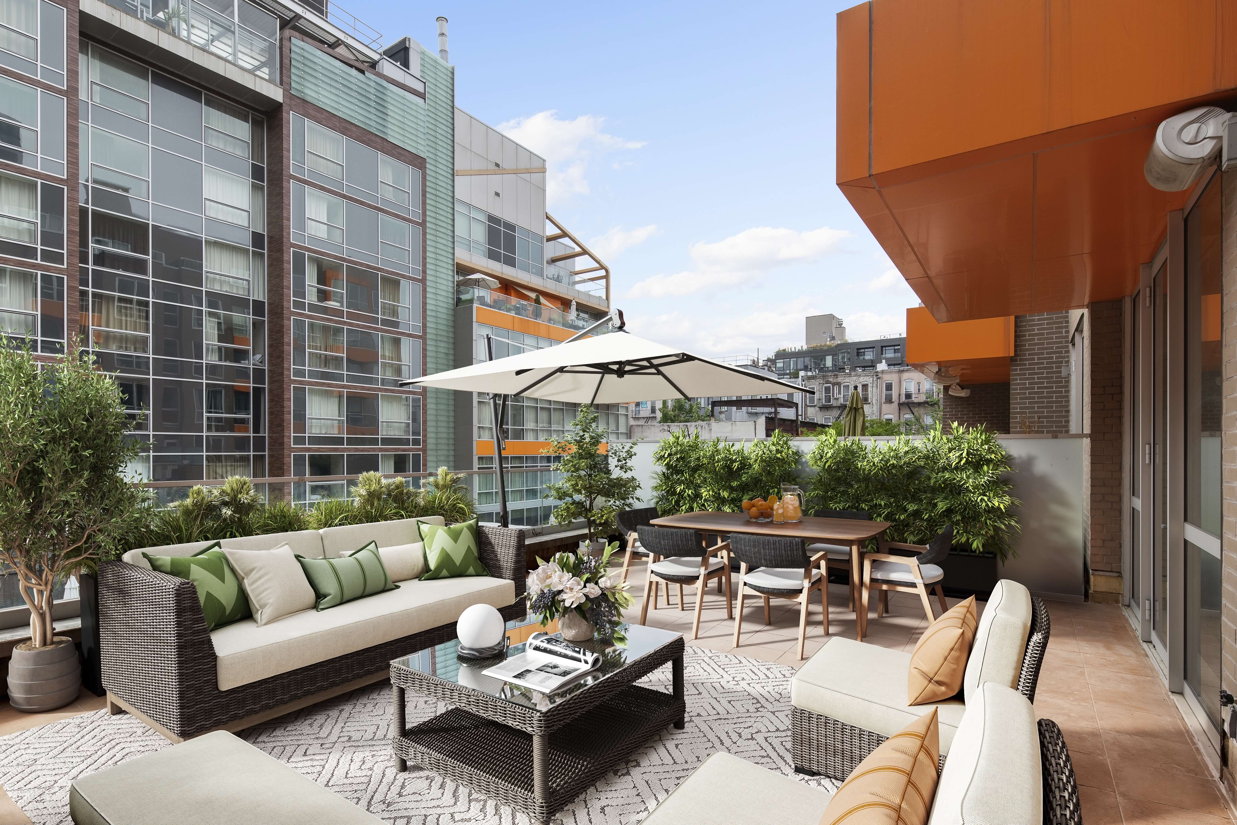 a view of a patio with couches and a table and chairs under an umbrella