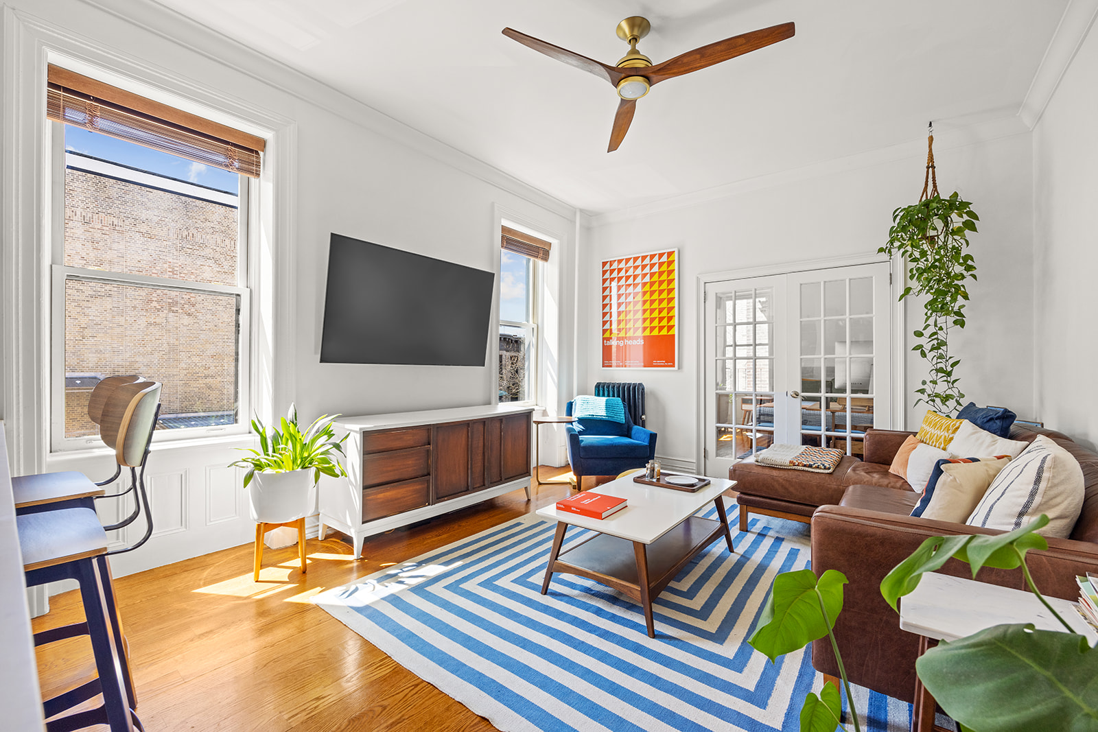 a living room with furniture a flat screen tv and a large window