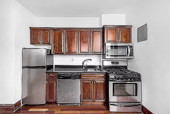 a kitchen with granite countertop a refrigerator stove and sink