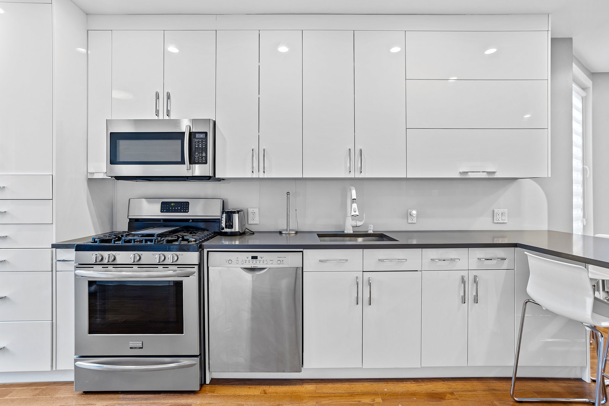 a kitchen with granite countertop a stove a sink and a microwave