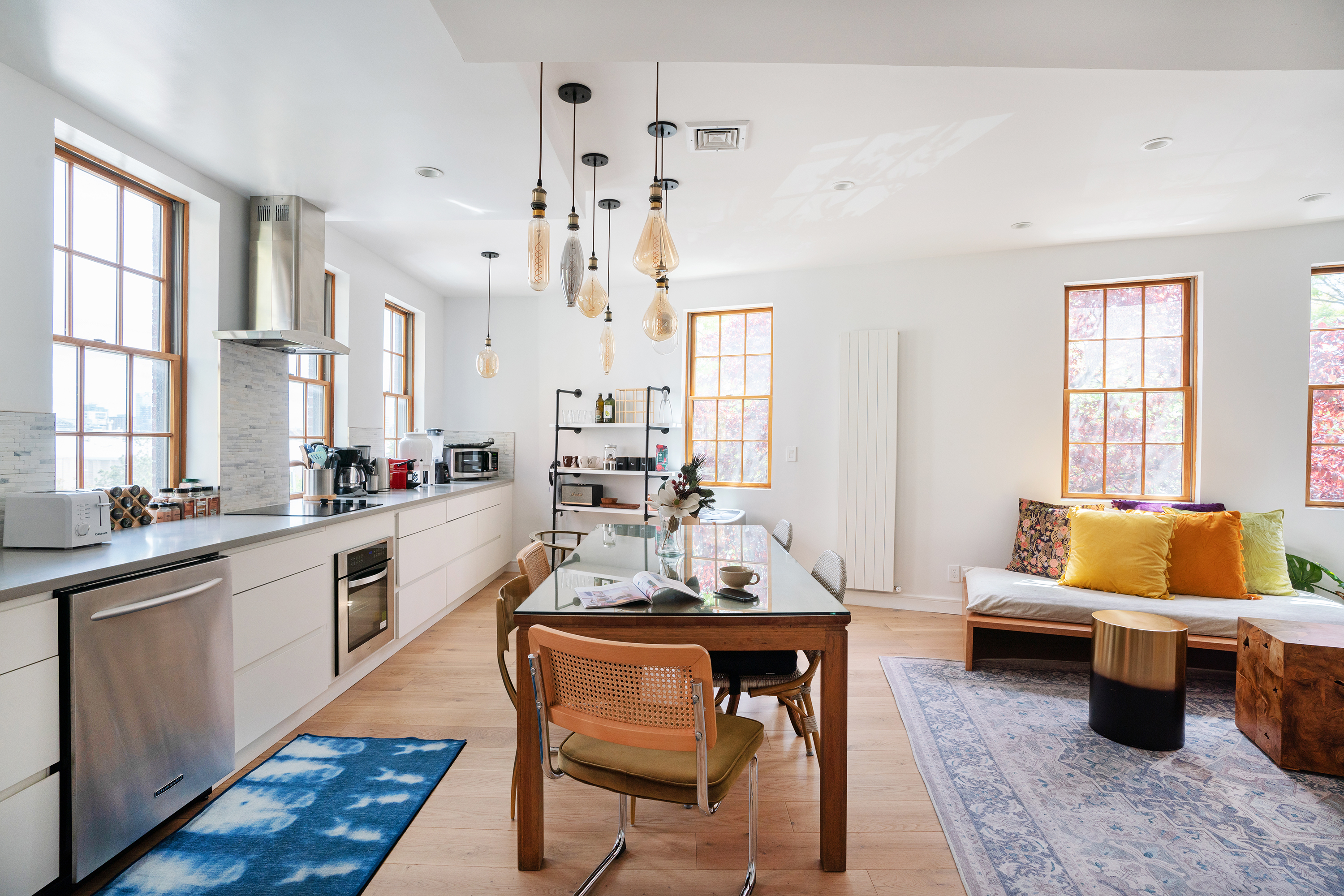 a living room with granite countertop furniture a rug kitchen view and a large window