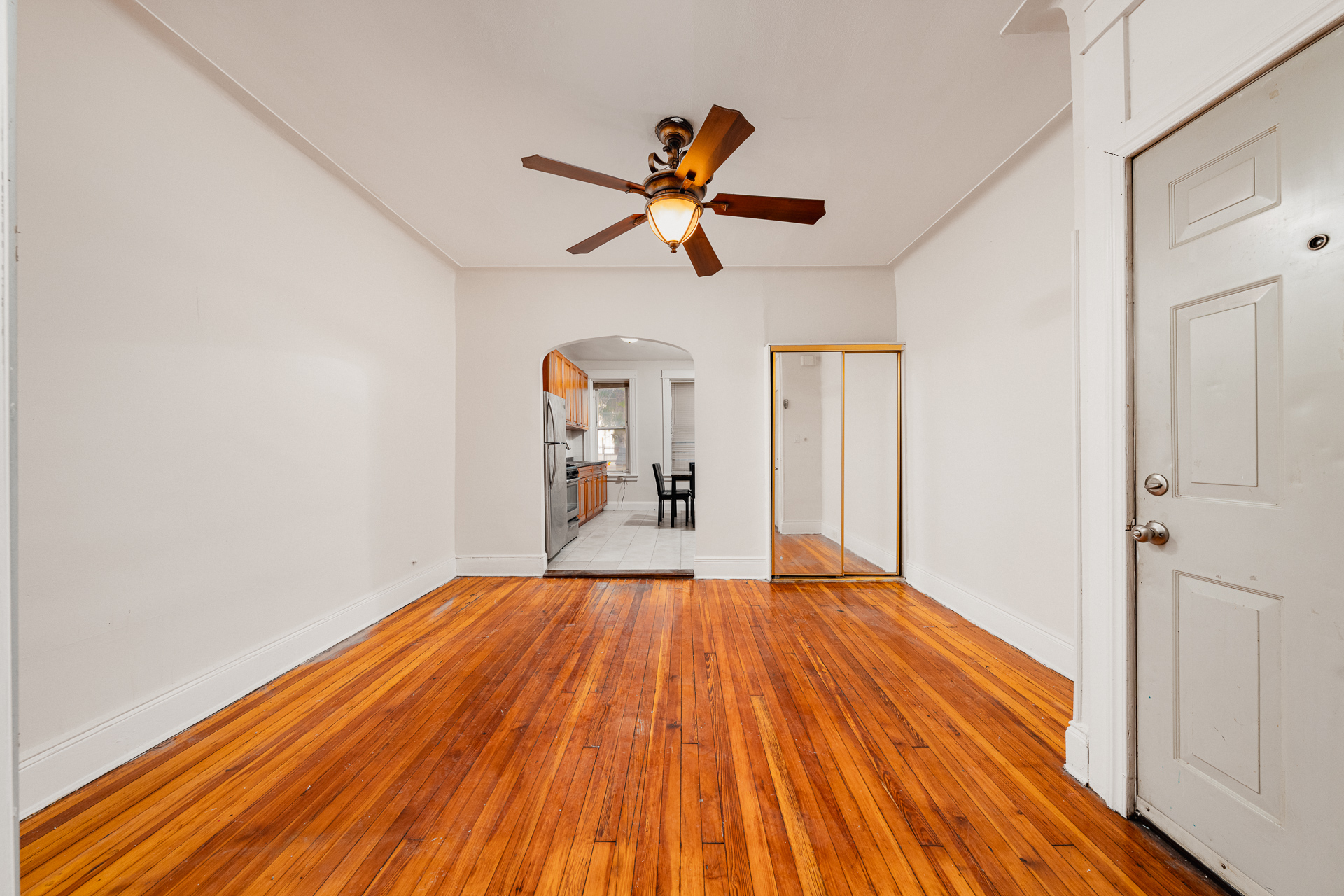 a view of empty room with wooden floor