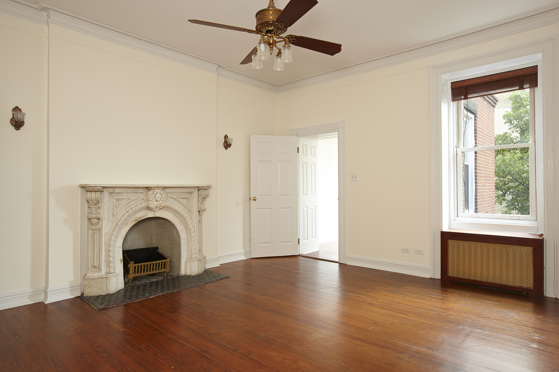 a view of an empty room with a fireplace and a window