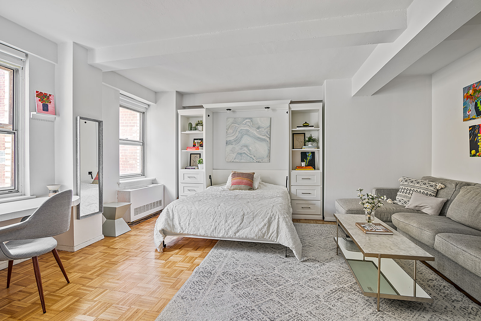 a bedroom with a bed couch and windows