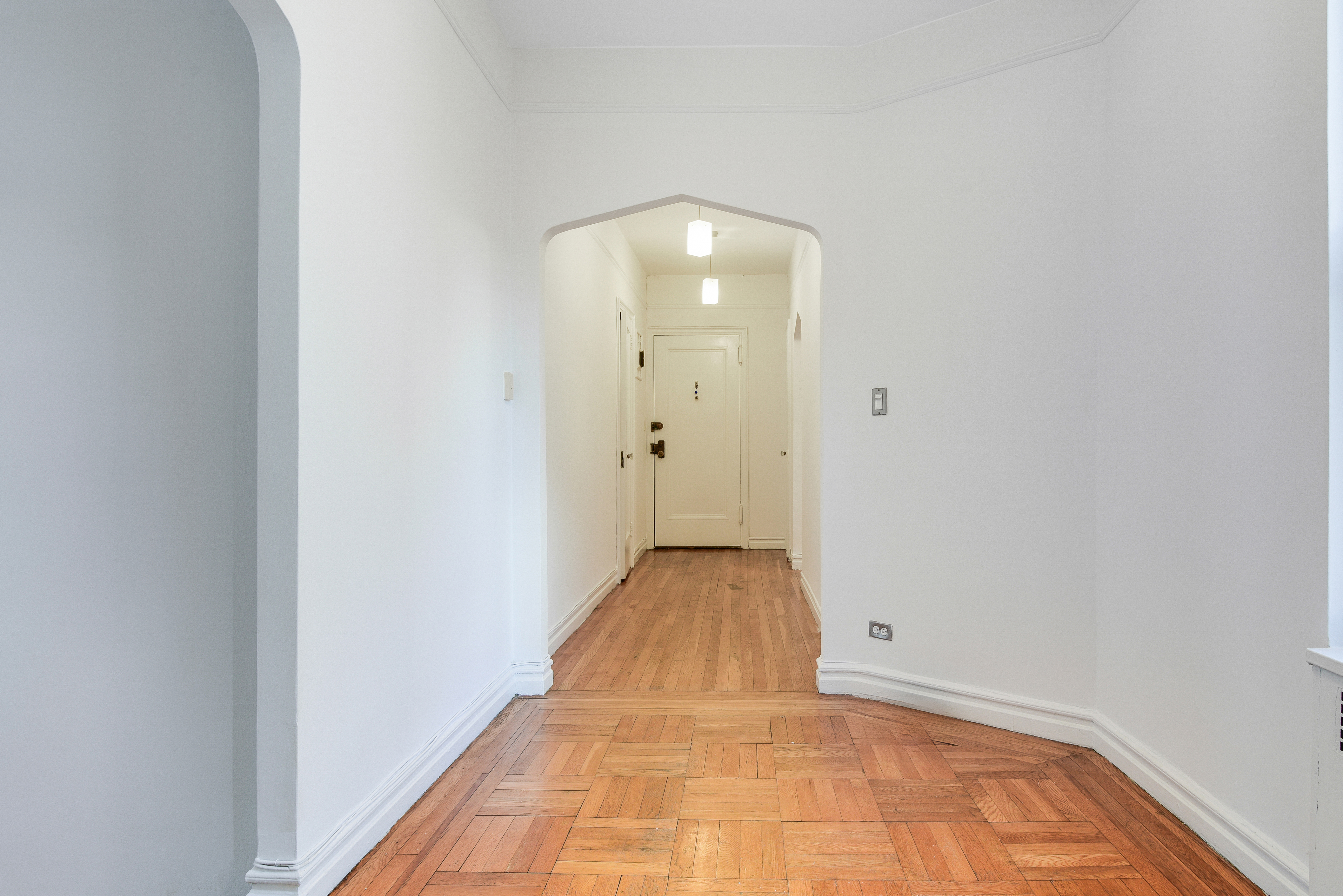 a view of a hallway with wooden floor