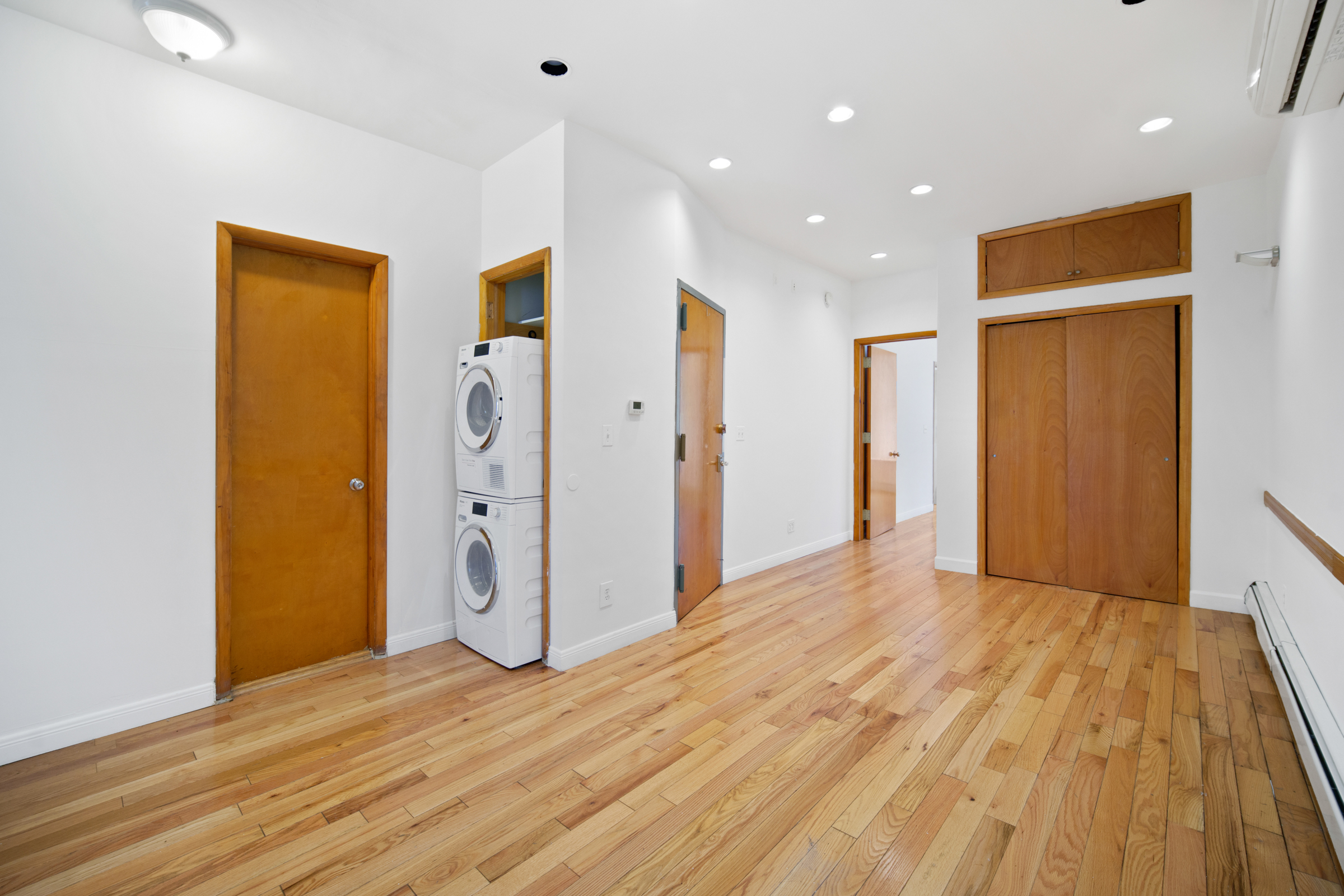 a view of empty room with wooden floor