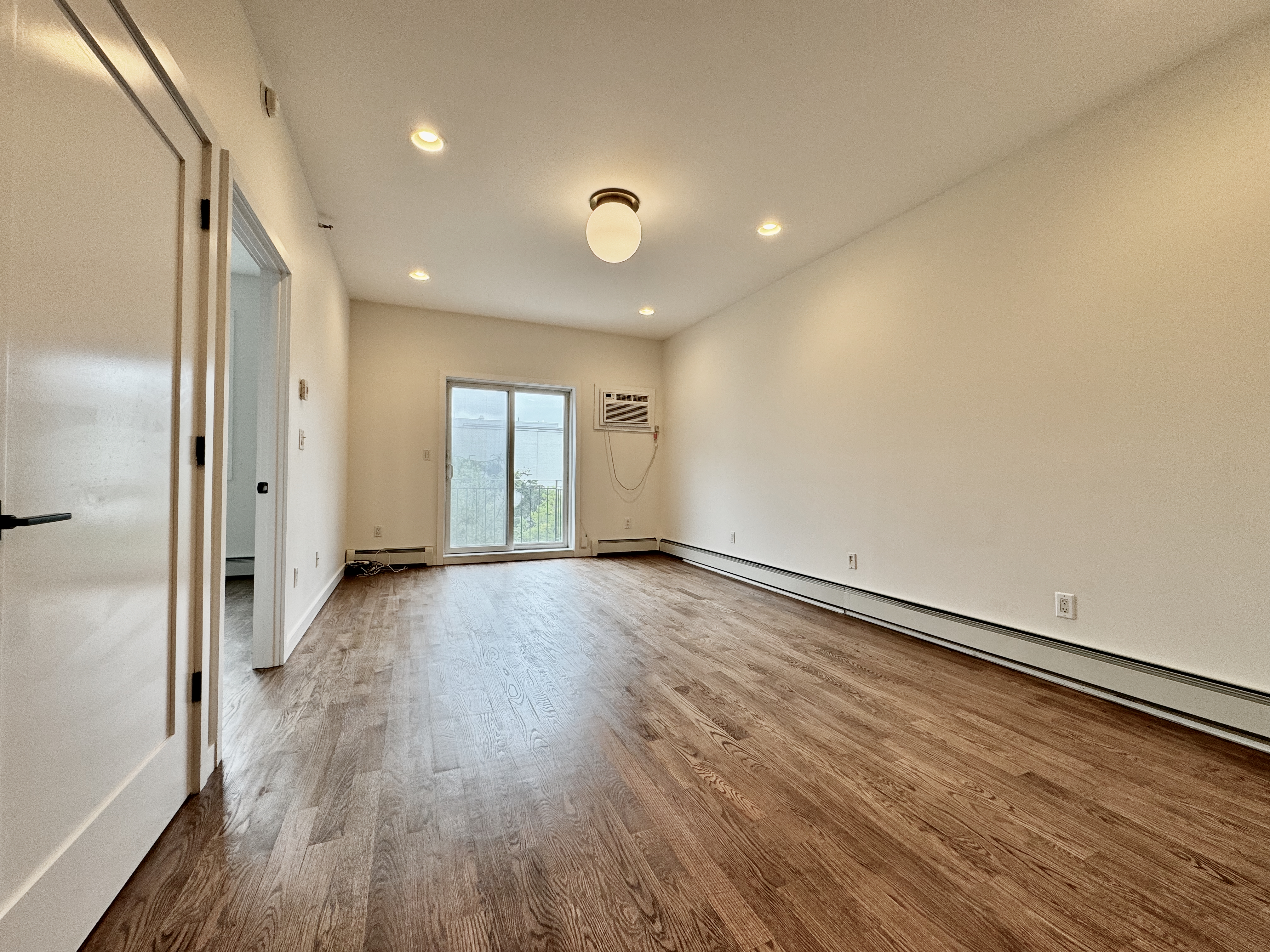 a view of a room with wooden floor and window