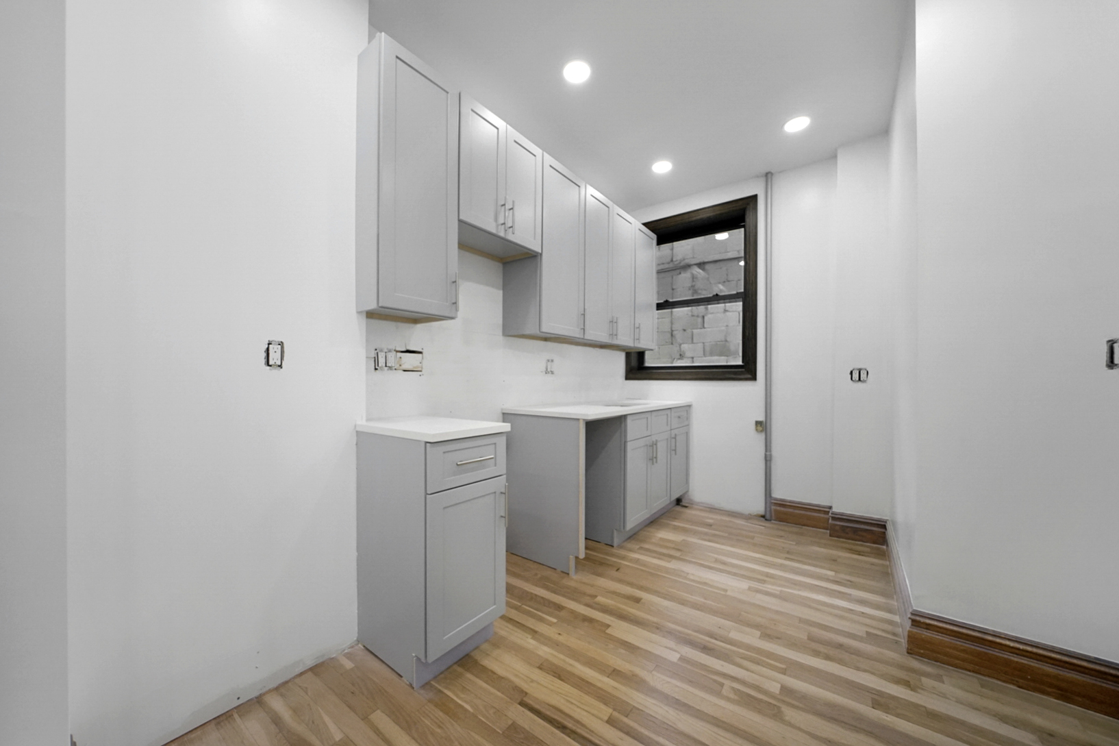 a view of a kitchen with wooden floor and electronic appliances