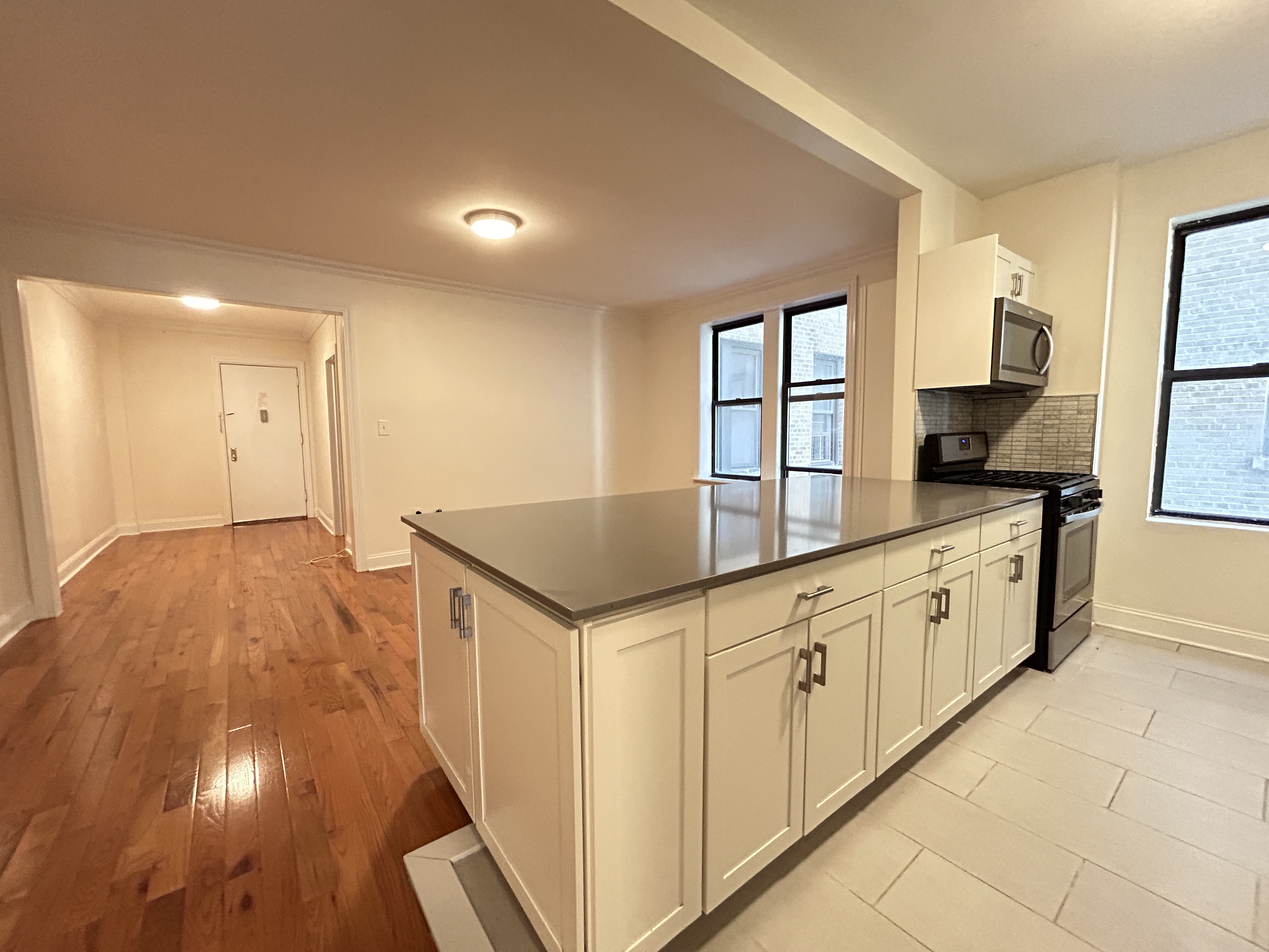 a kitchen with granite countertop a stove a sink and a refrigerator