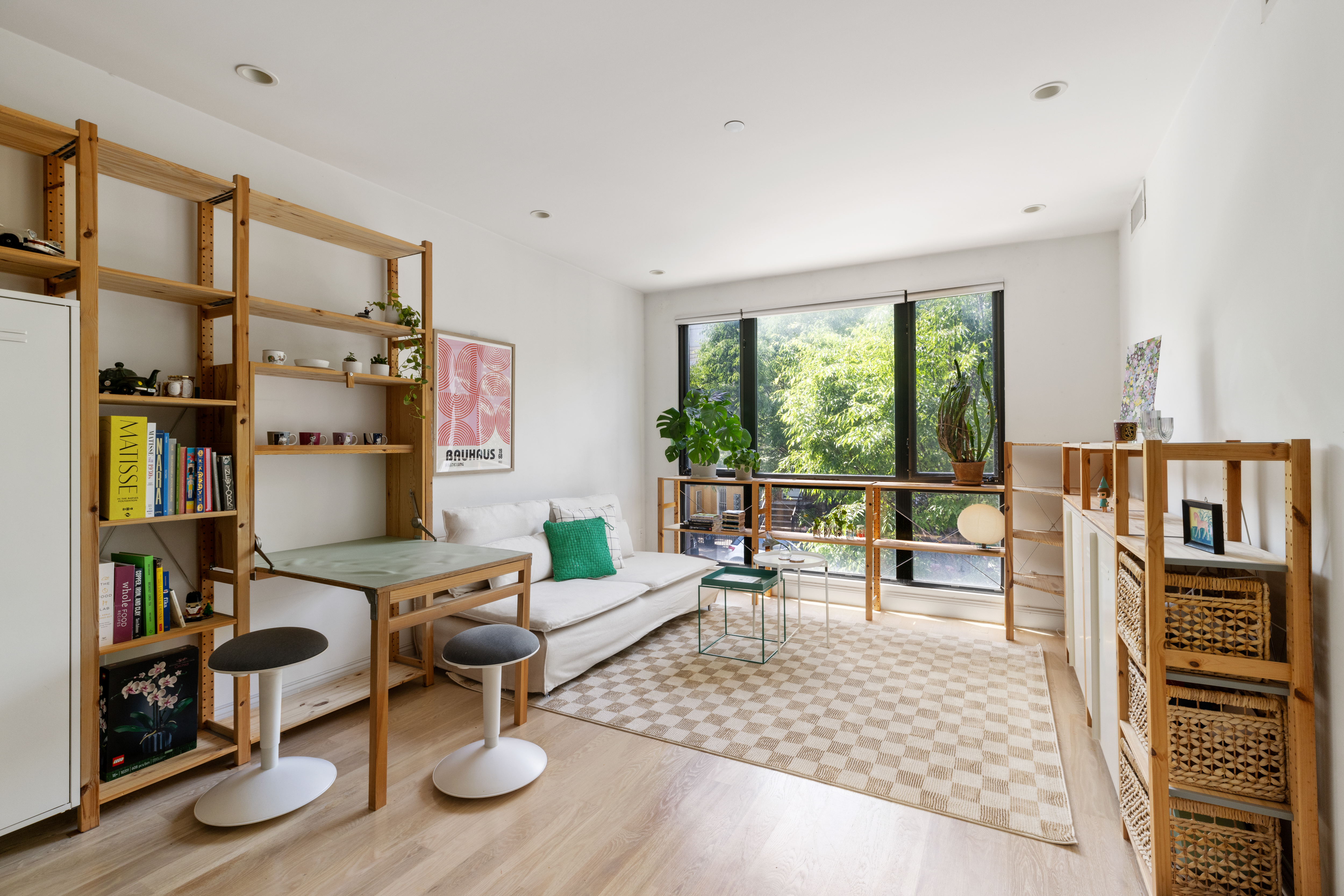 a living room with furniture large window and wooden floor