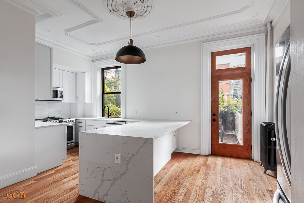 a kitchen with stainless steel appliances granite countertop a sink a stove and a refrigerator