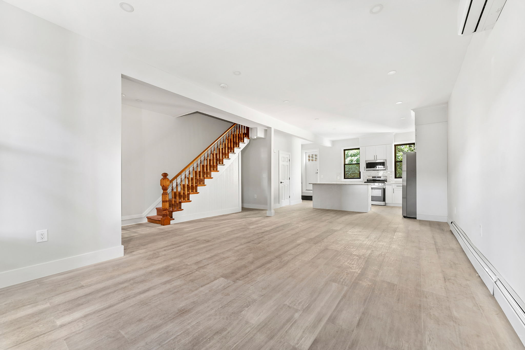 a view of a livingroom with wooden floor and stairs