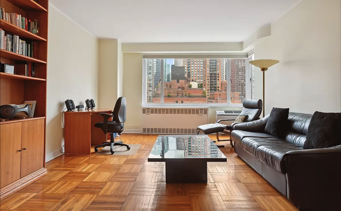 a living room with furniture and a book shelf