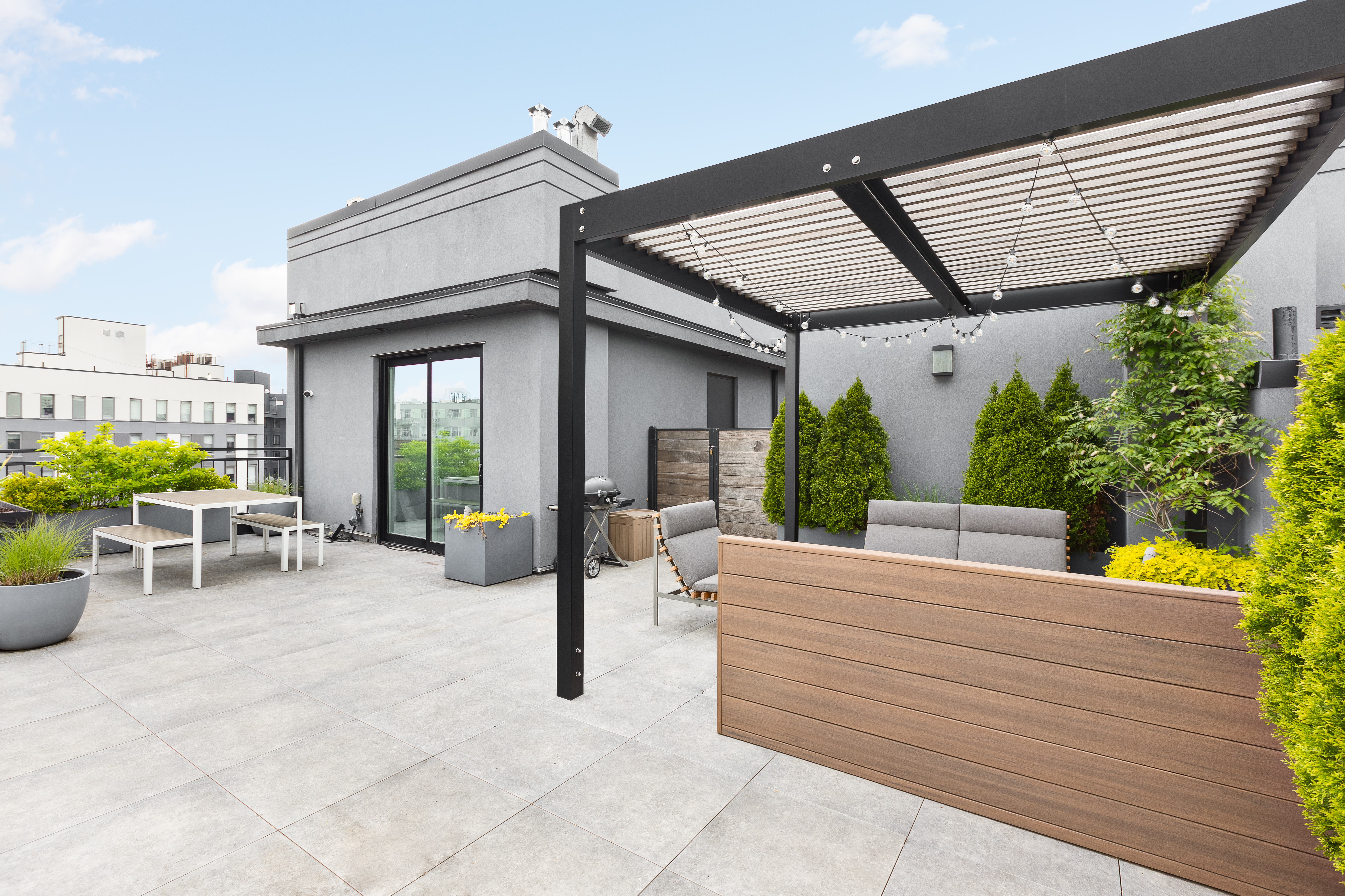 a view of a patio with table and chairs potted plants and large tree