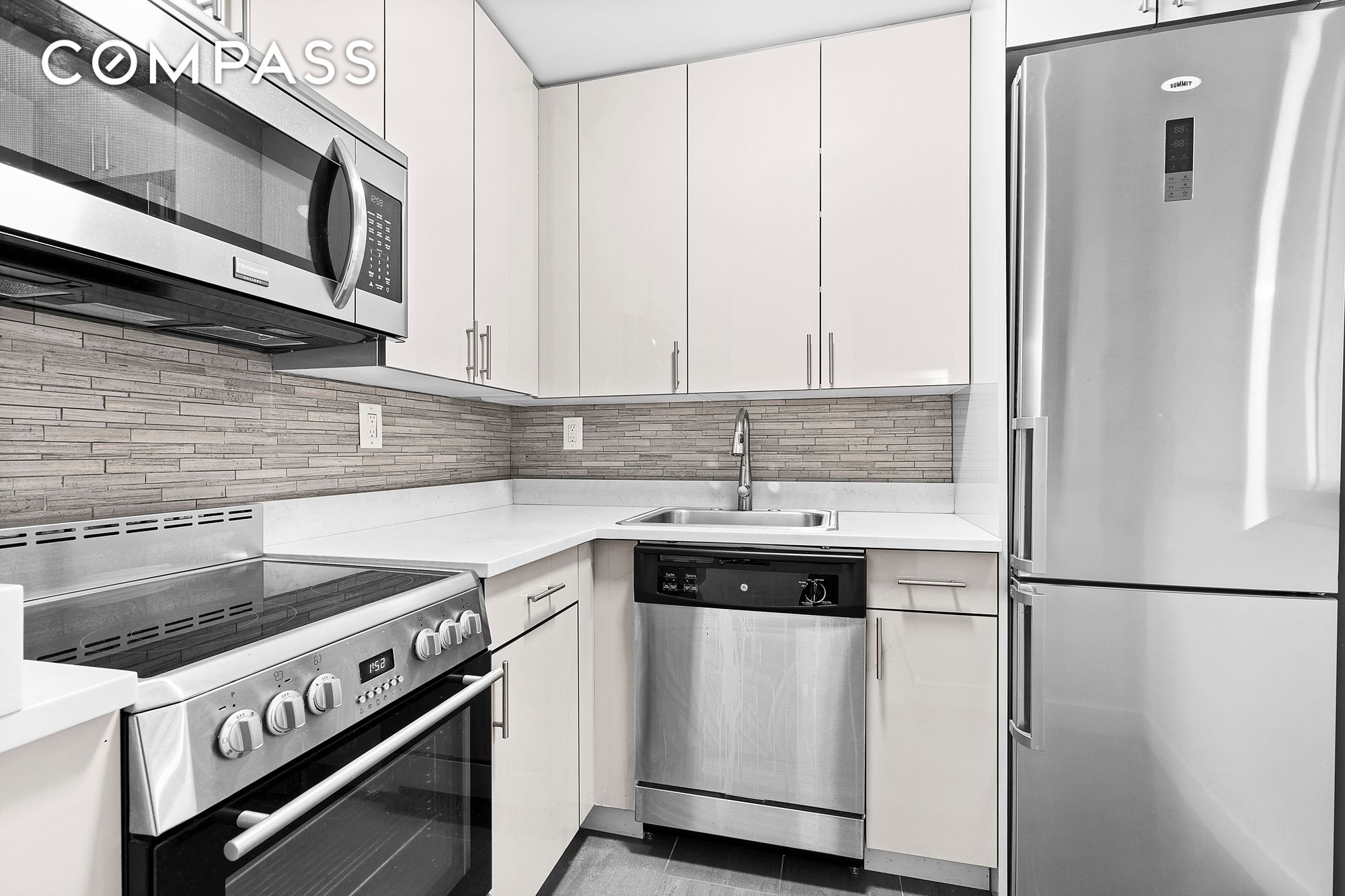 a kitchen with stainless steel appliances granite countertop white cabinets a sink and a stove