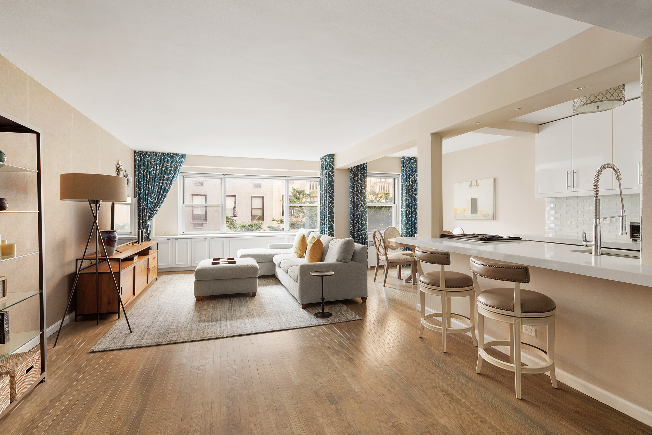 a living room with furniture large window and wooden floor