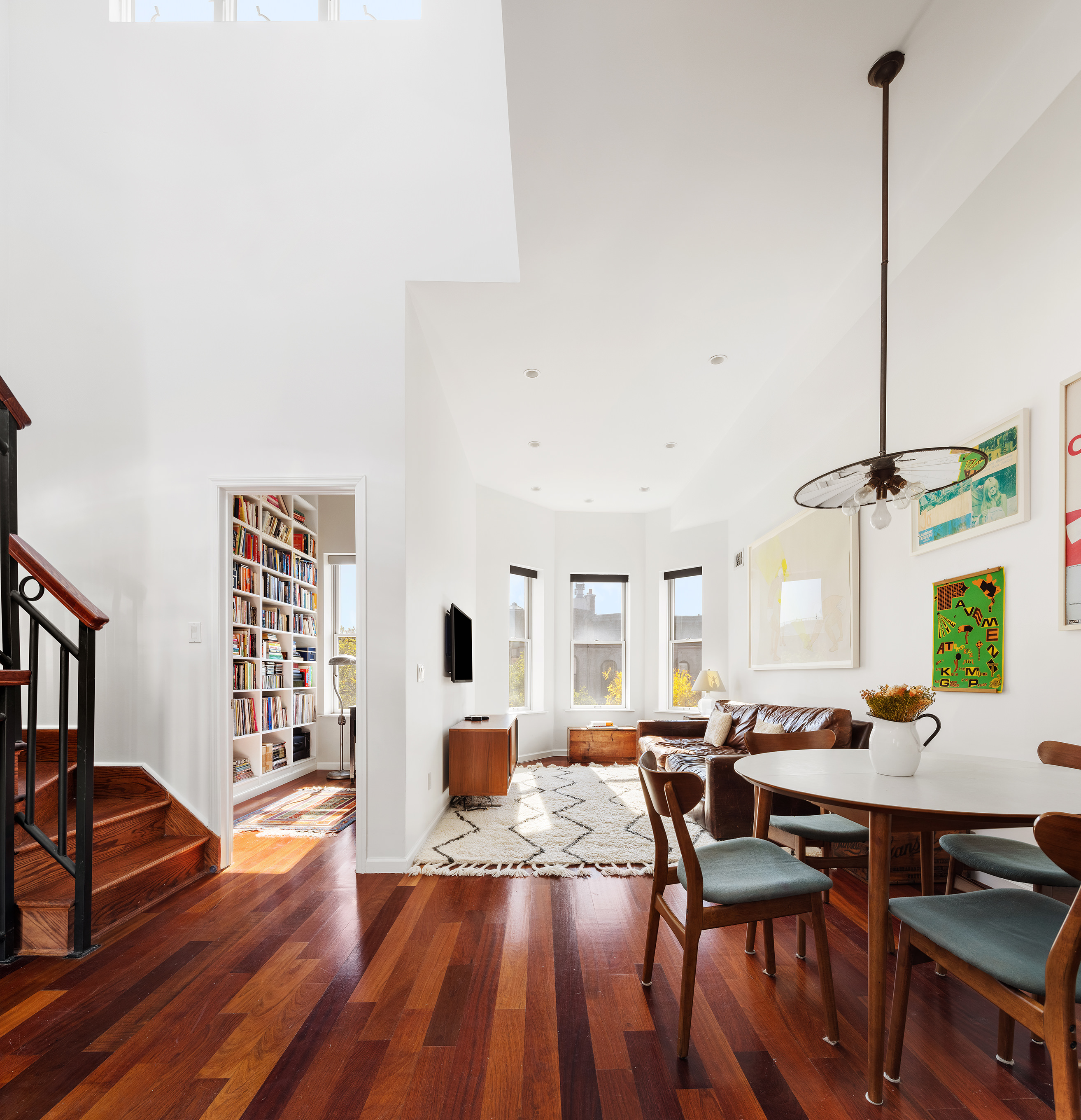 a living room with furniture dining table and wooden floor