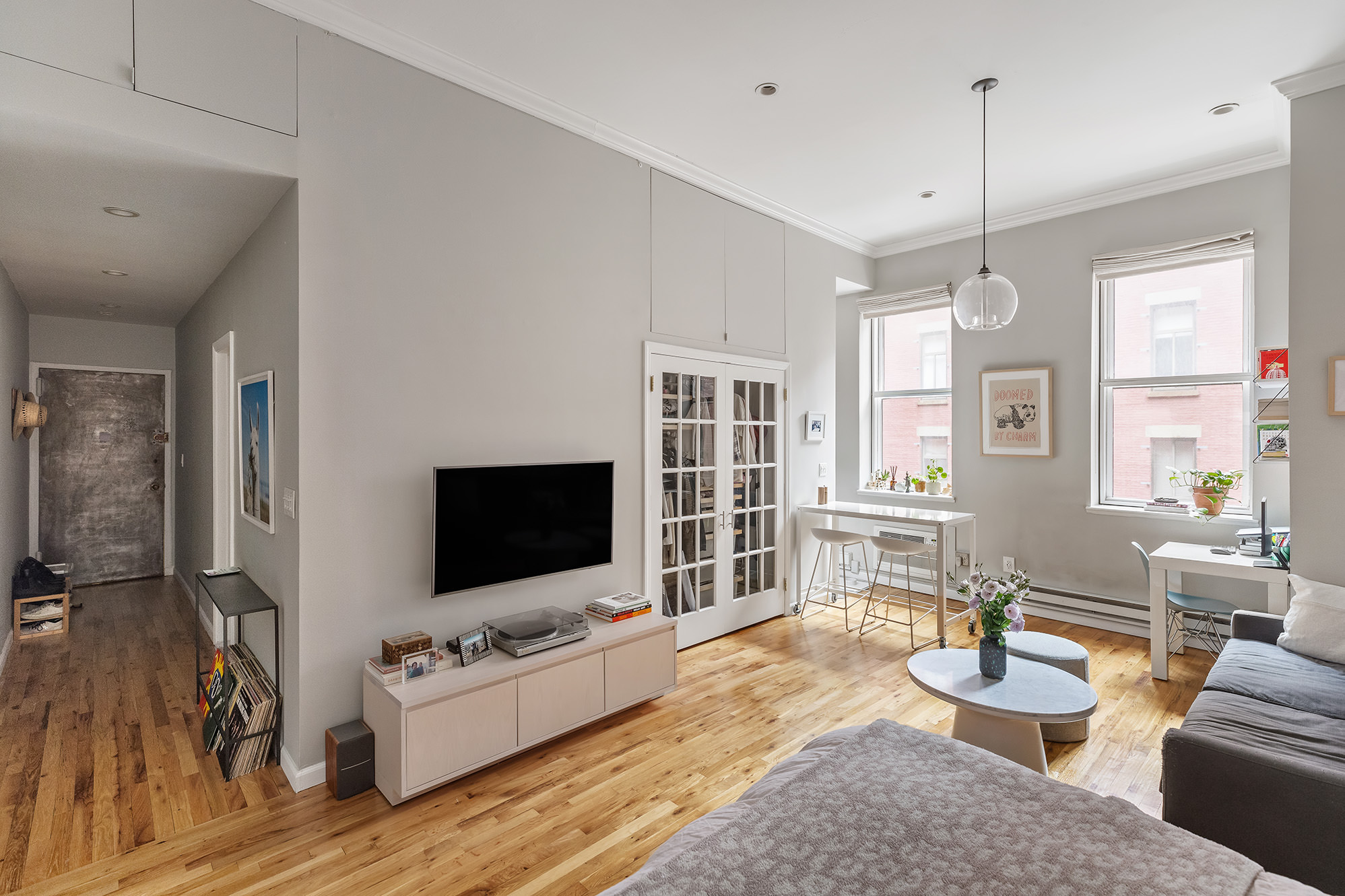 a living room with furniture a flat screen tv and kitchen view