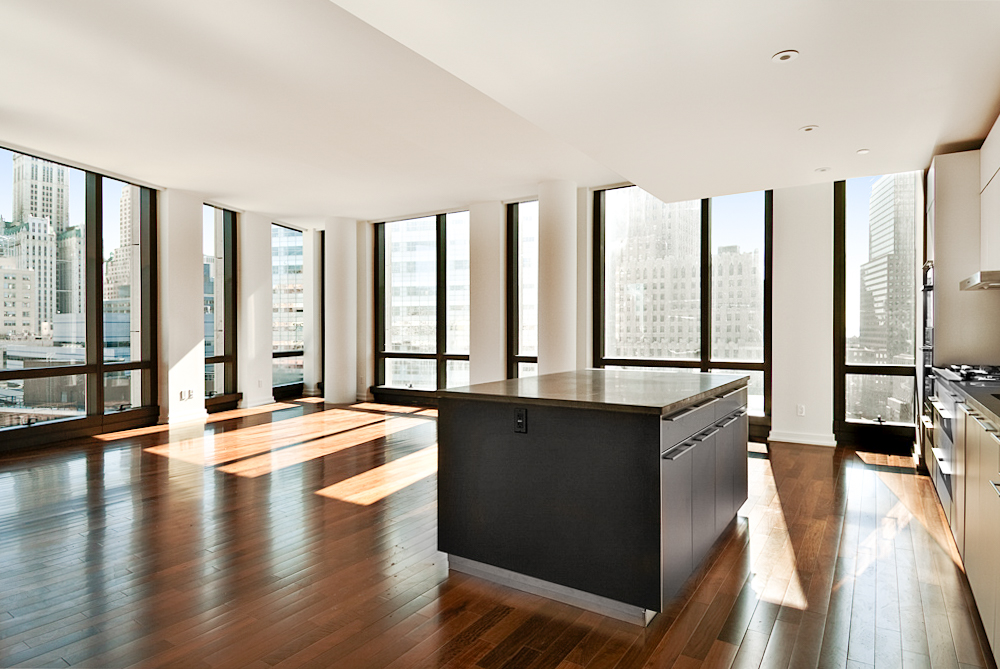 a large kitchen with stainless steel appliances a lot of counter space and a wooden floors