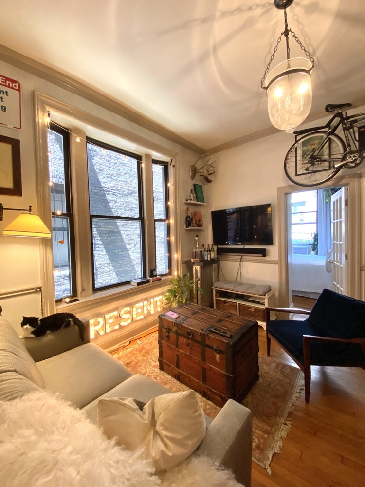 a living room with furniture a flat screen tv and a large window